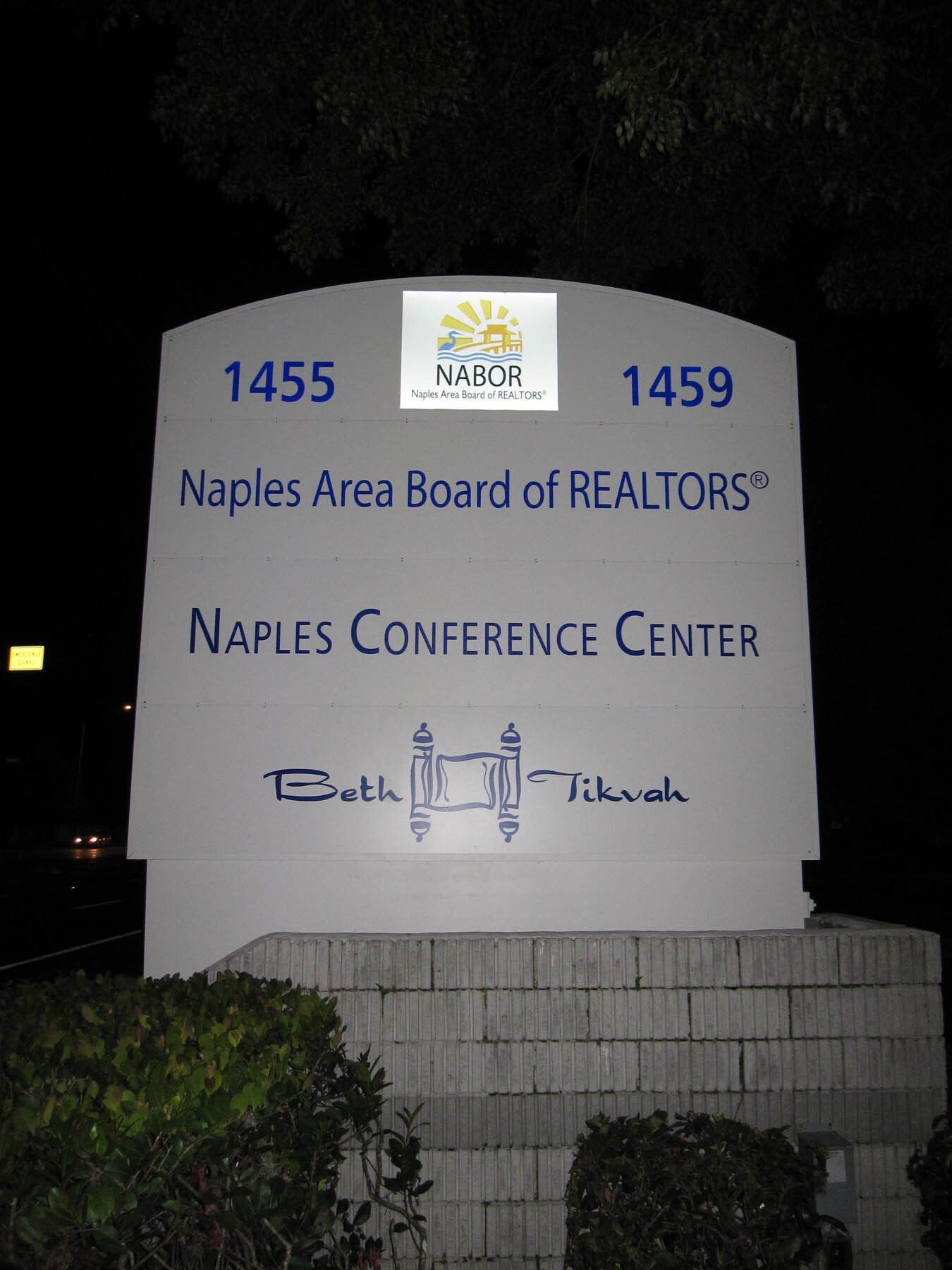 A sign for the naples area board of realtors