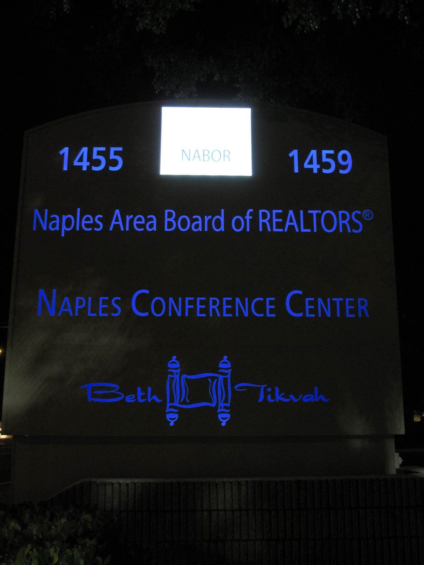 A sign for the naples area board of realtors