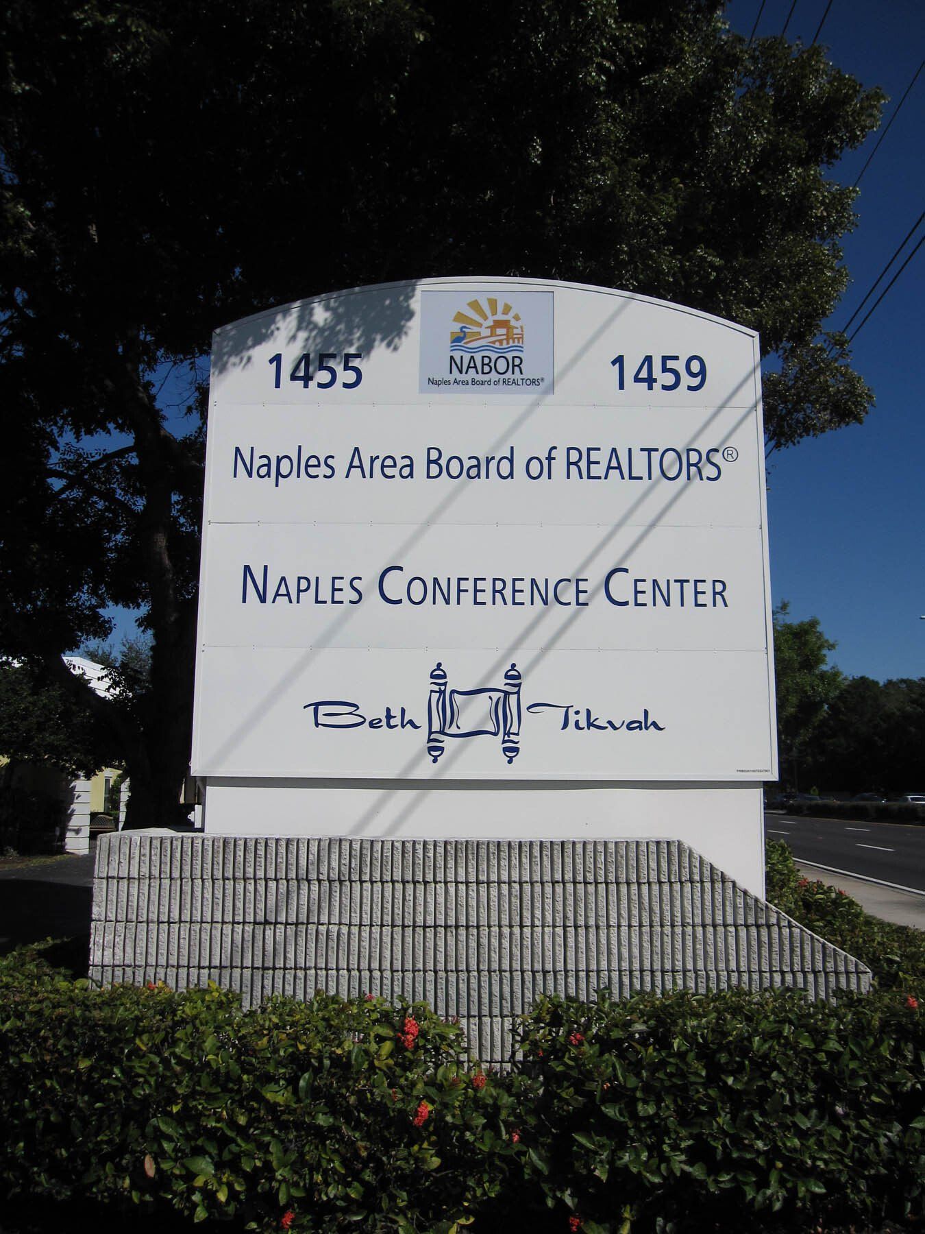 A sign for the naples area board of realtors
