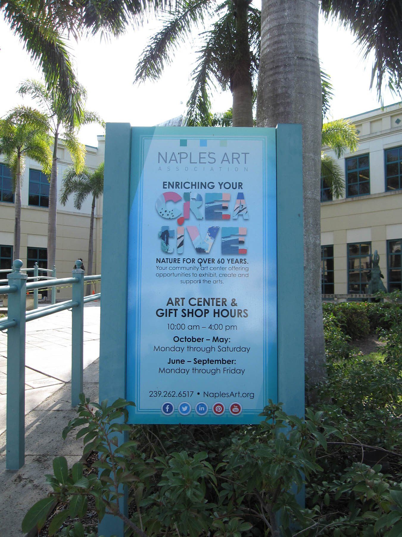 A sign for the naples art center and gift shop