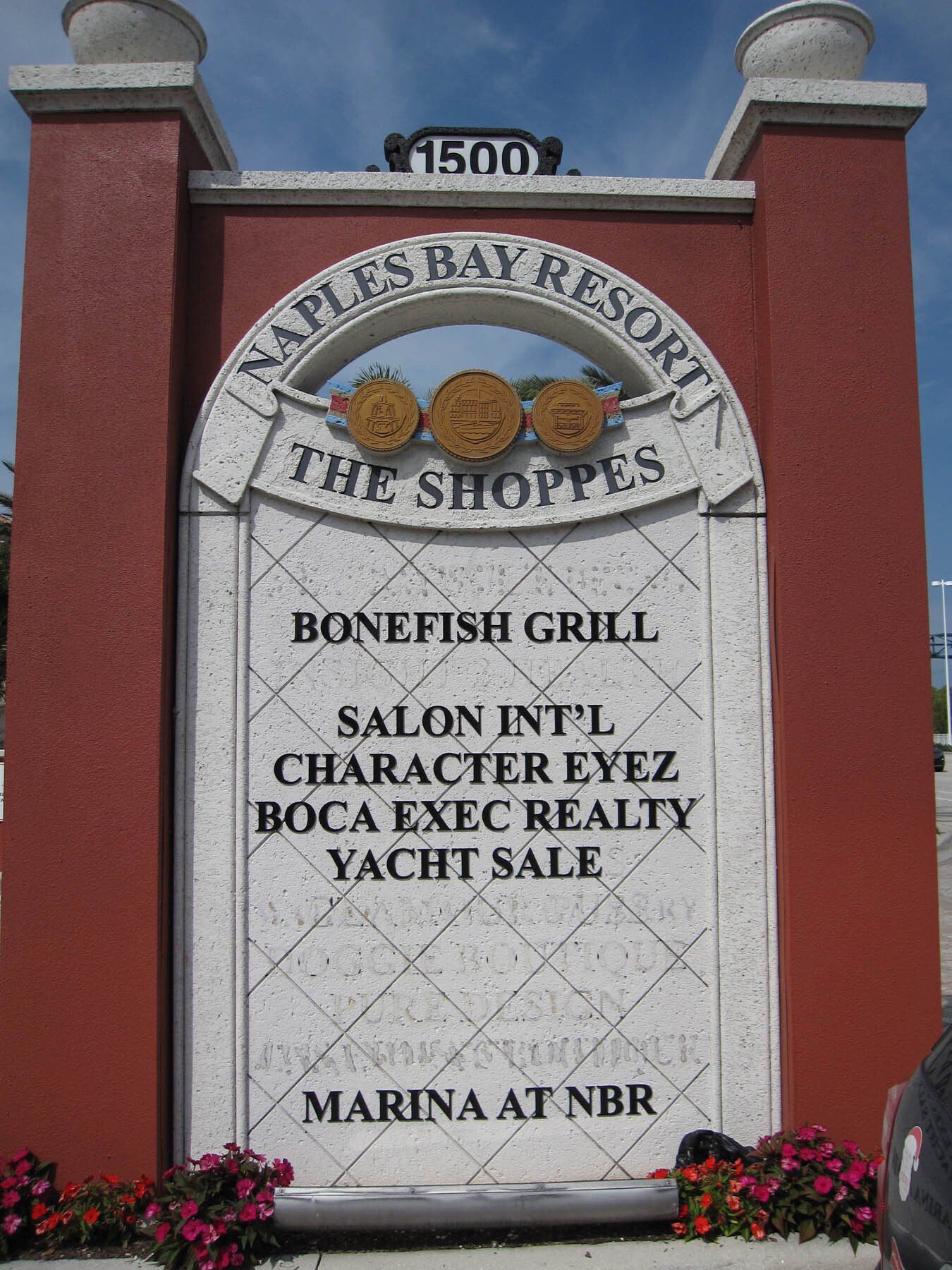 A sign for naples bay resort says bonefish grill salon intl character eyez boca exec realty yacht sale and marina at nbr