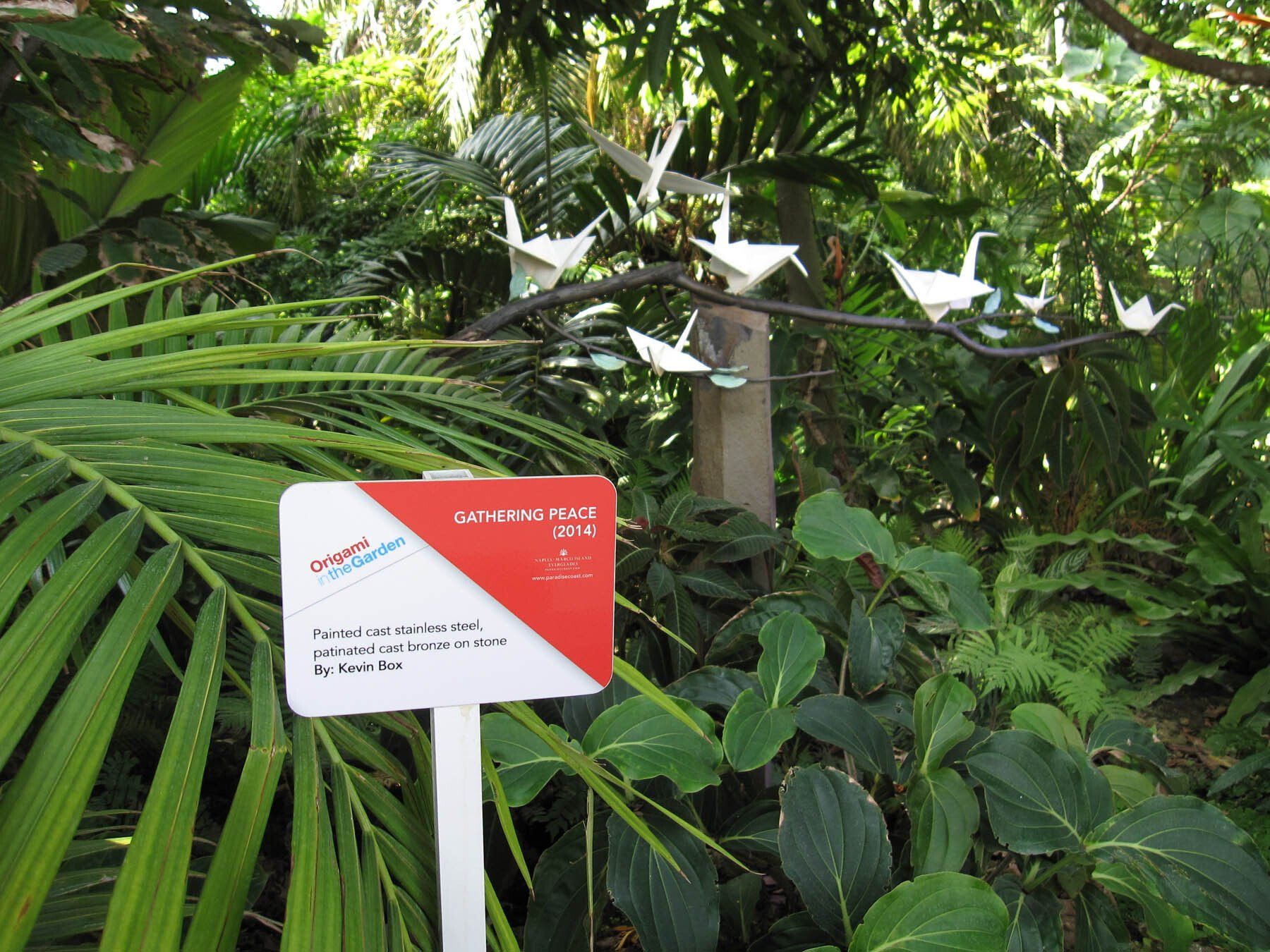 A red and white sign in the middle of a forest