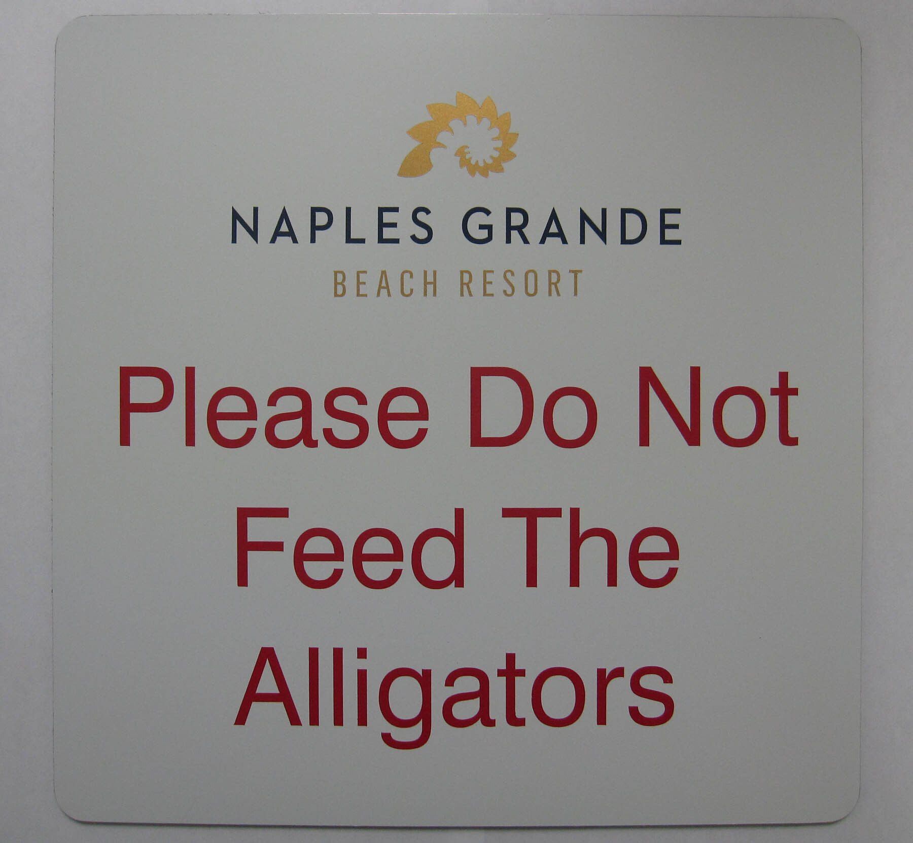 A sign that says please do not feed the alligators