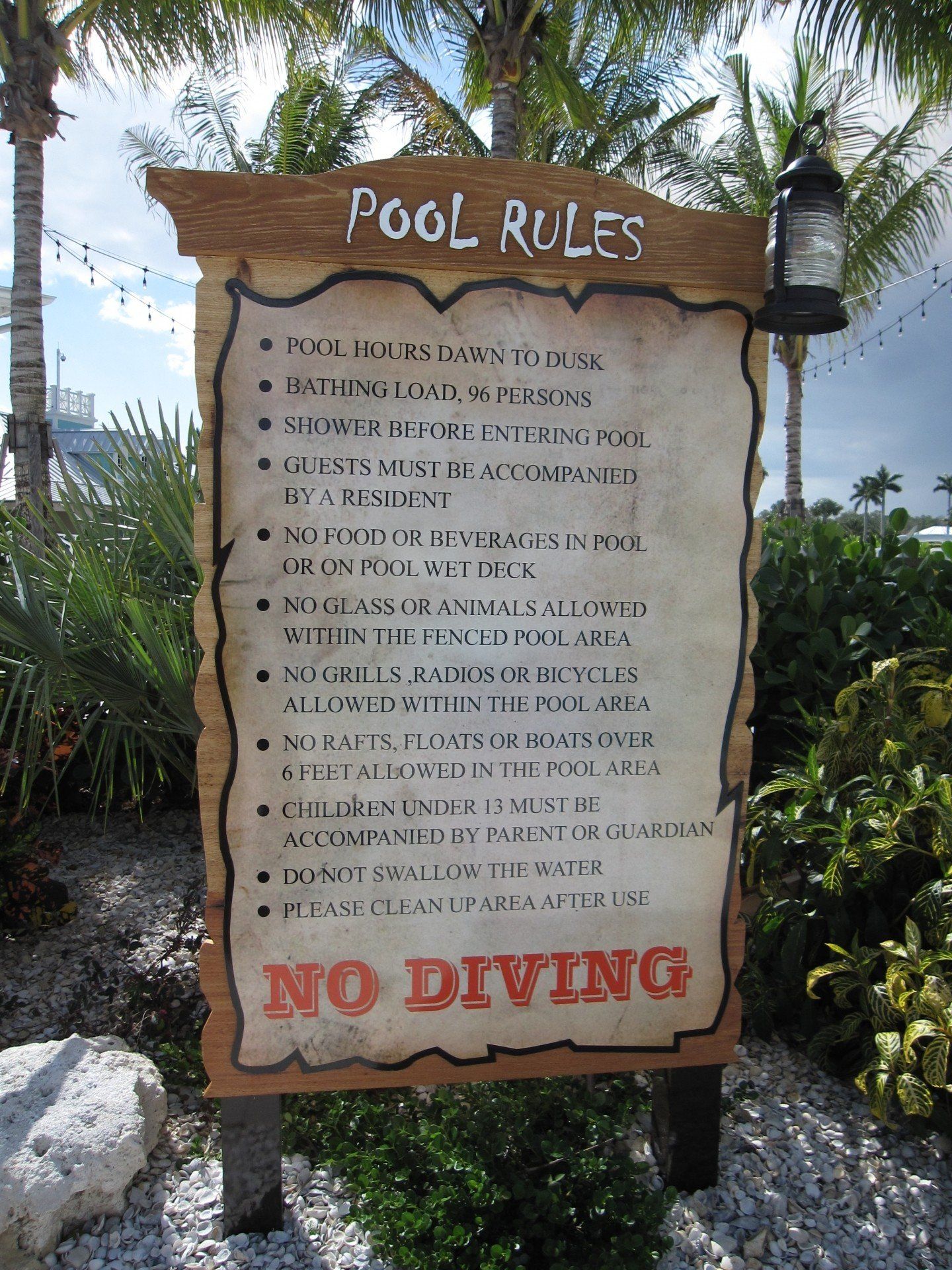 A sign that says pool rules and no diving on it