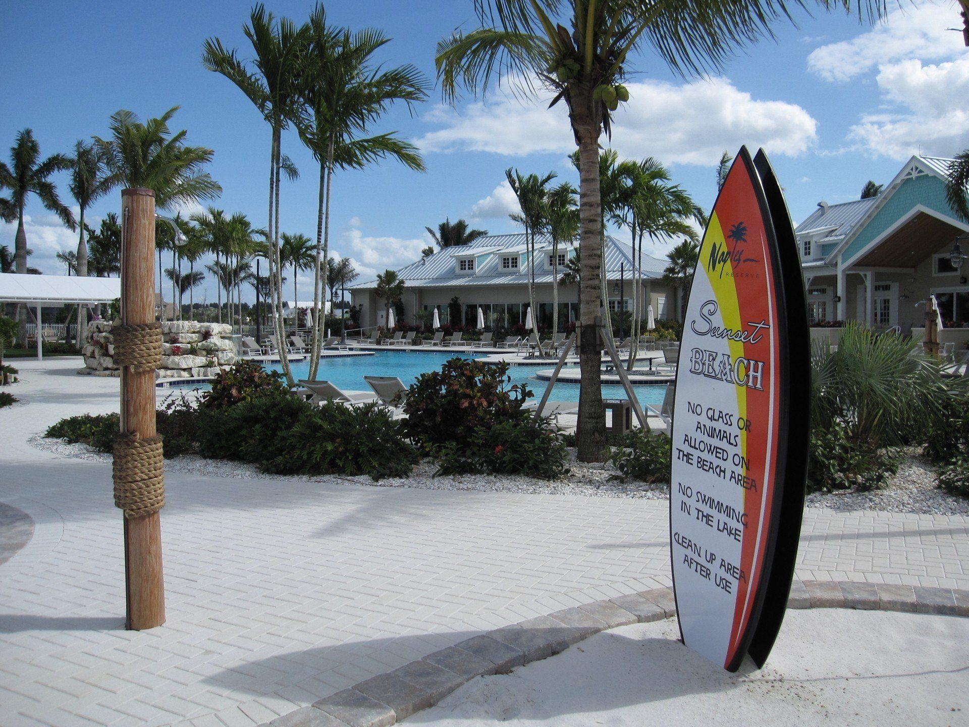 A surfboard shaped information sign for  Sunset beach at Naples Reserve Club.