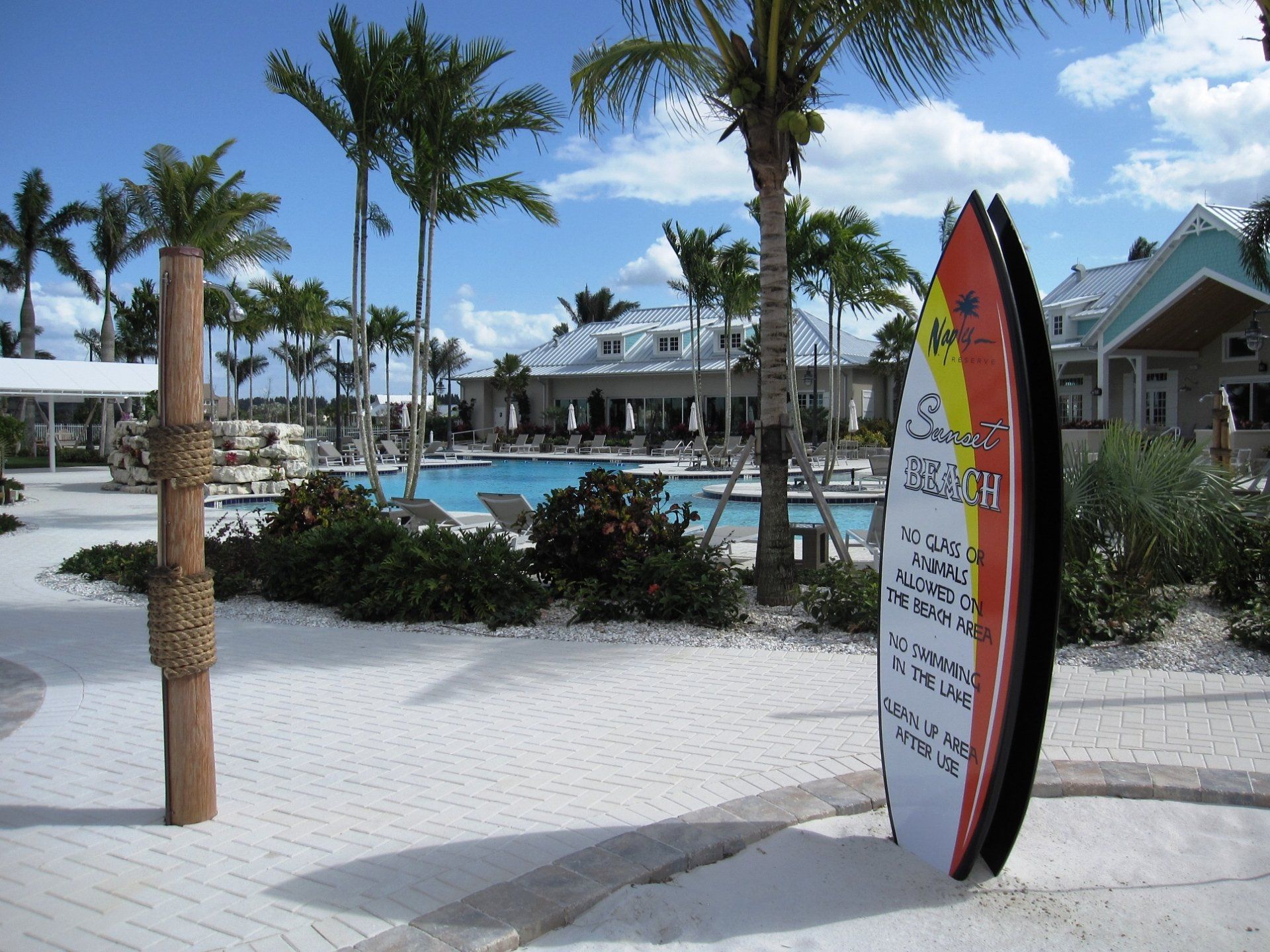 A surfboard shaped information sign for  Sunset beach at Naples Reserve Club.