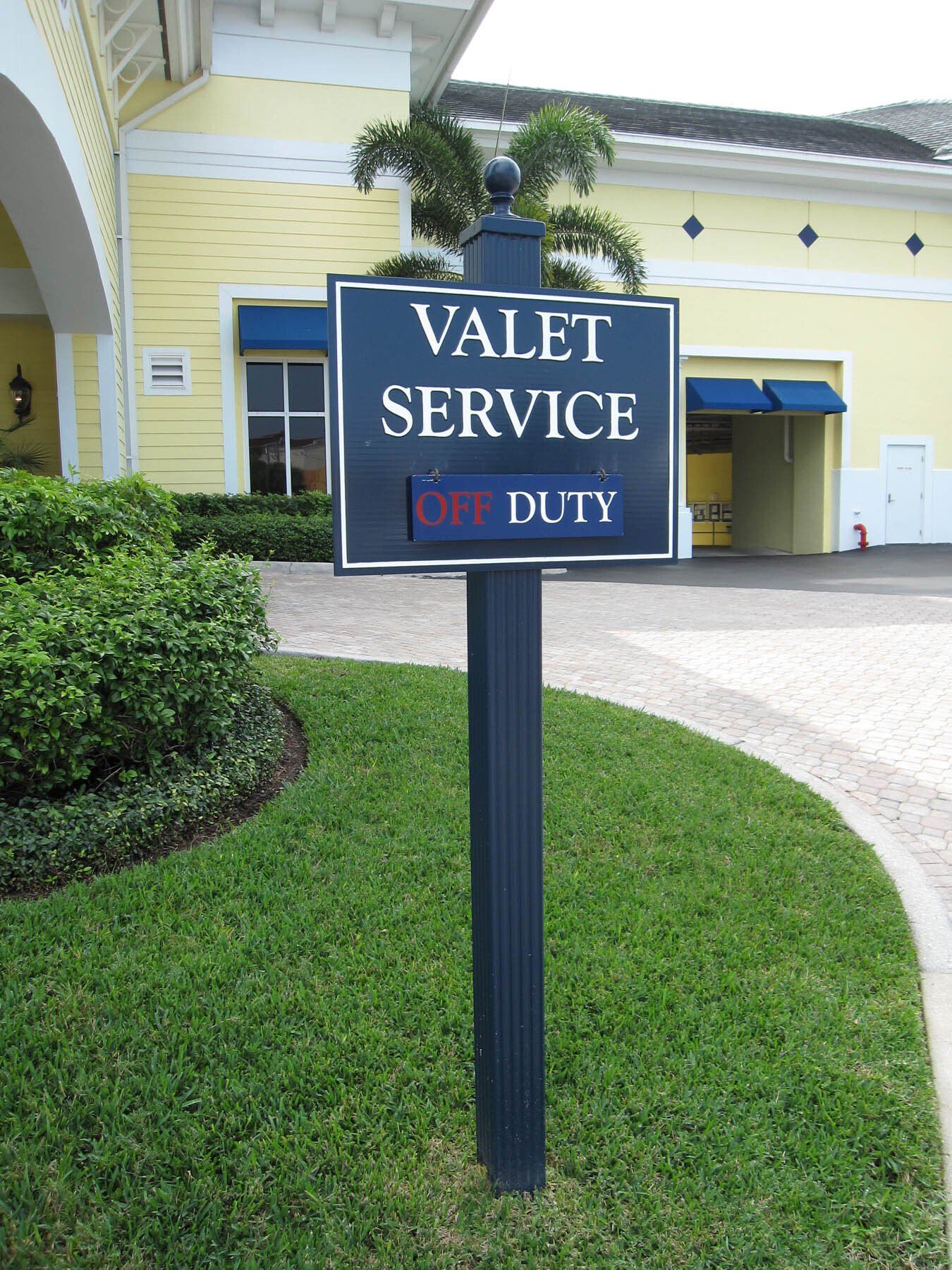 A valet service sign in front of a yellow building