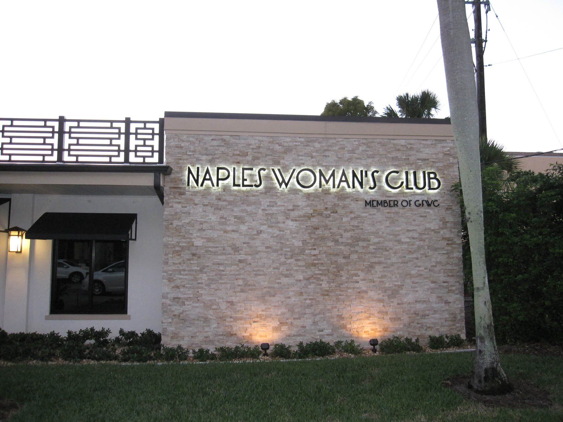 A building with a sign that says naples woman 's club