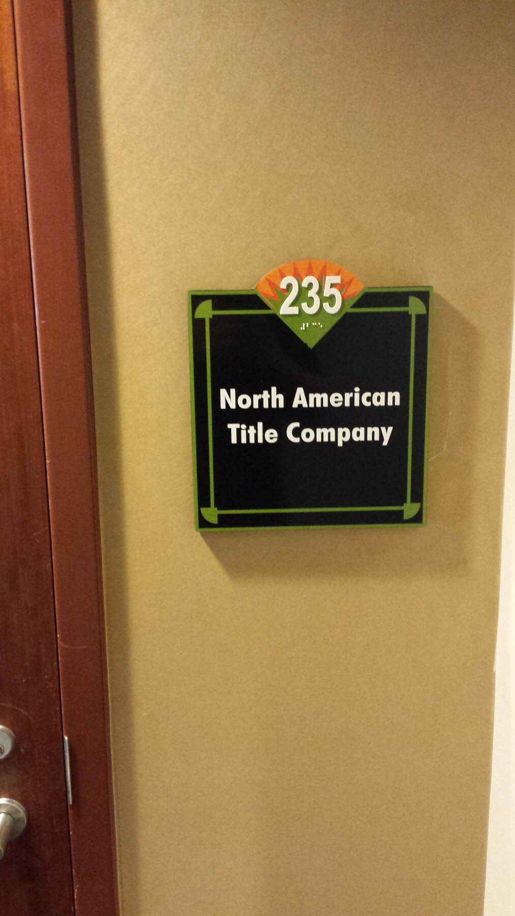A sign on a wall that says 235 north american title company
