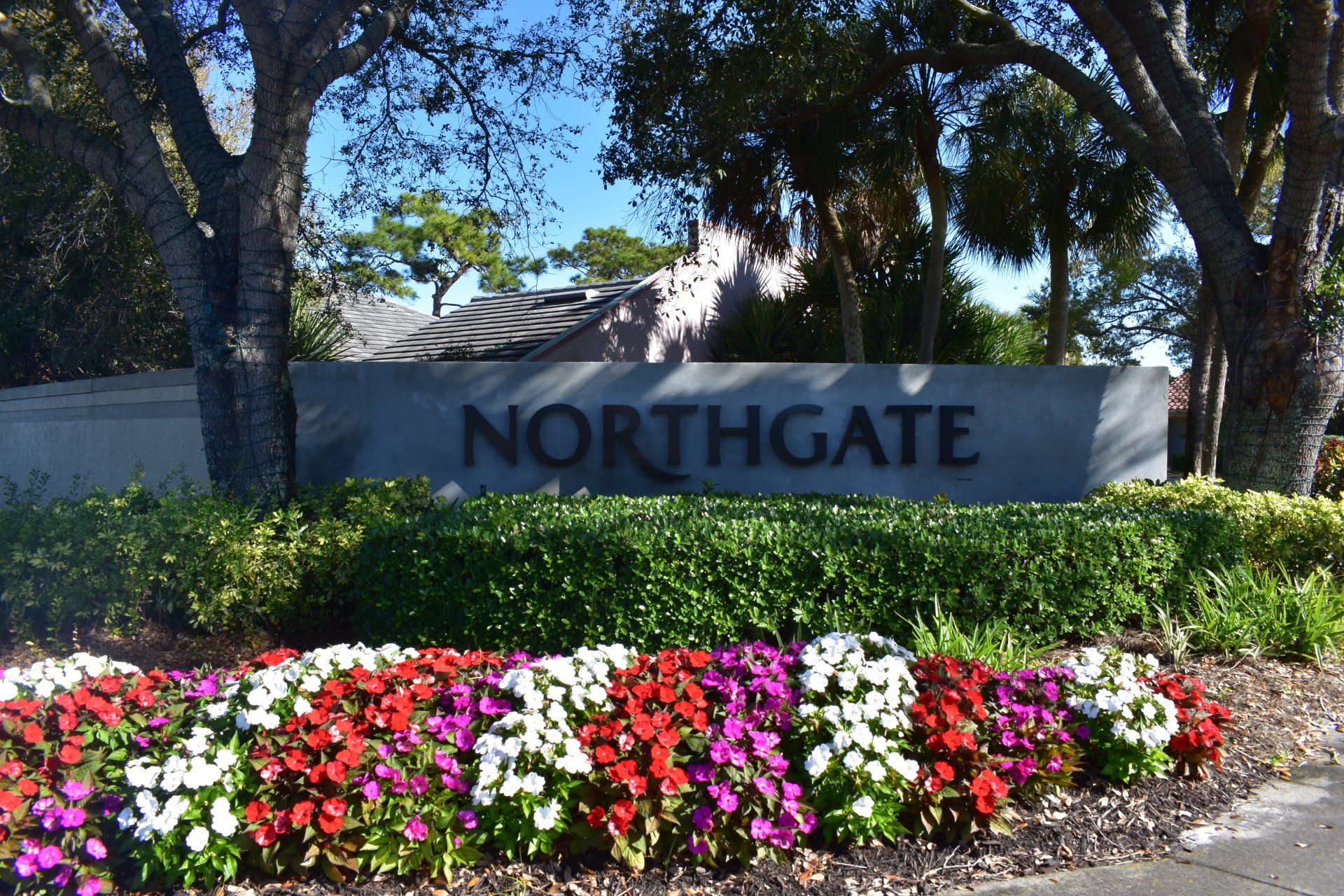 A sign for northgate is surrounded by flowers