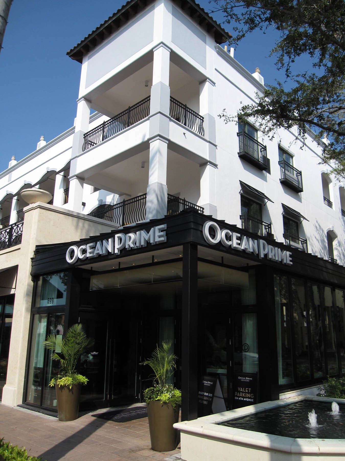 A white building with a black sign that says ocean prime