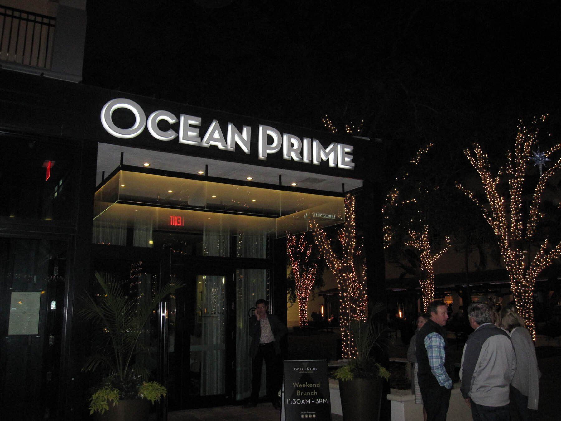 A group of people are standing outside of the ocean prime hotel