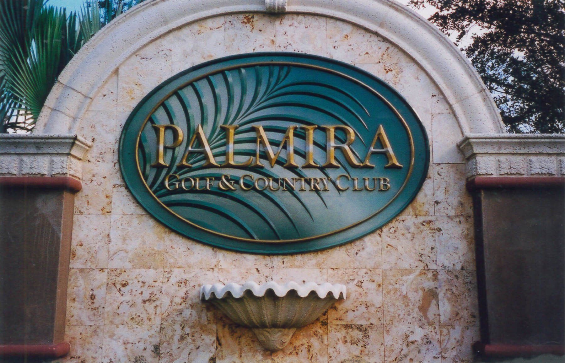 A palmira golf and country club sign on a stone wall