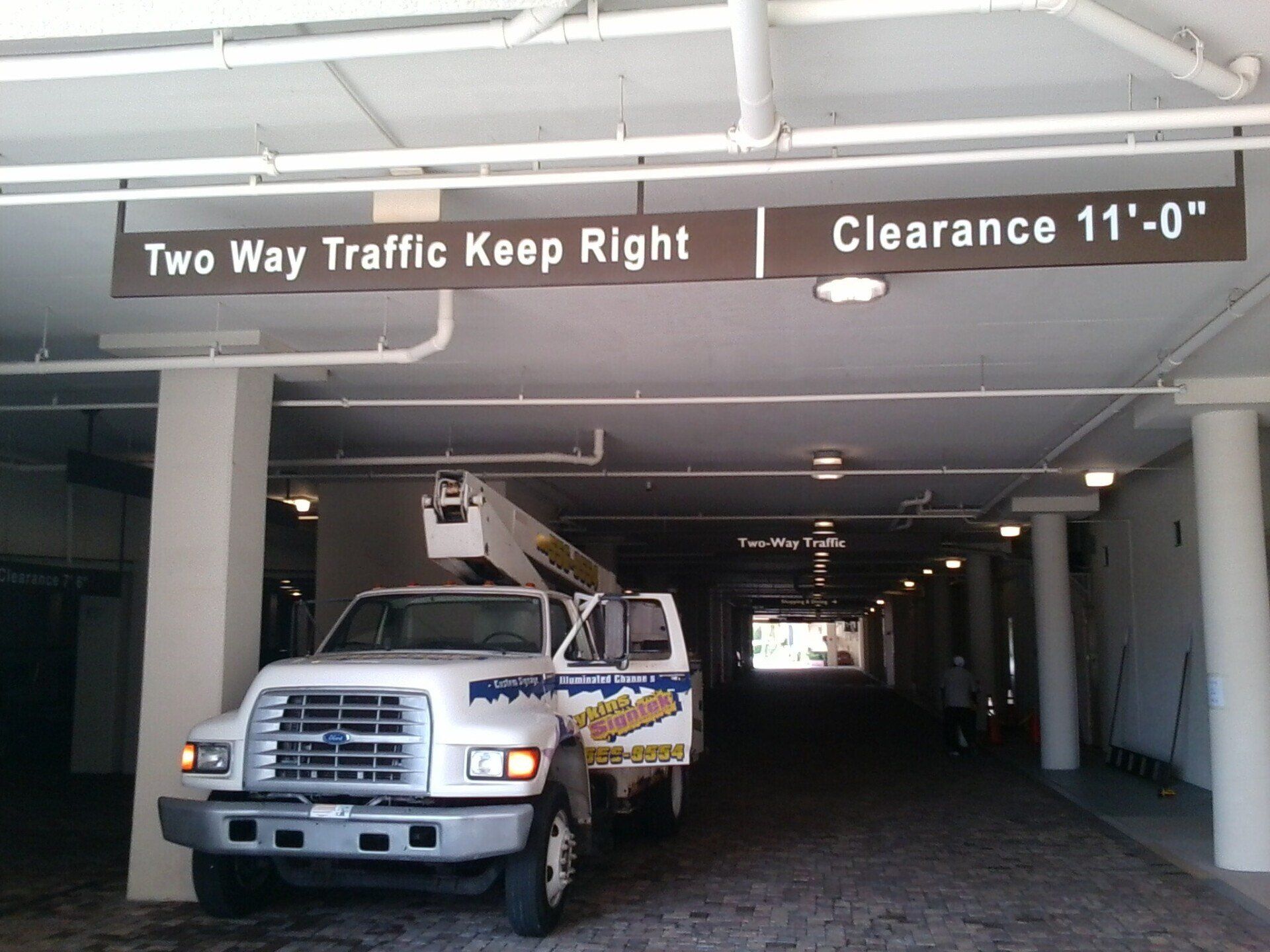 A truck is parked under a sign that says two way traffic keep right
