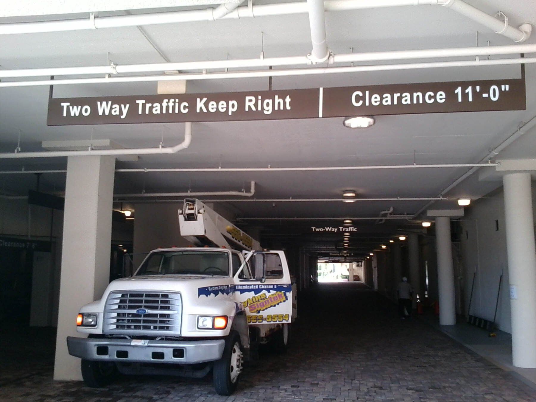 A truck is parked under a sign that says two way traffic keep right