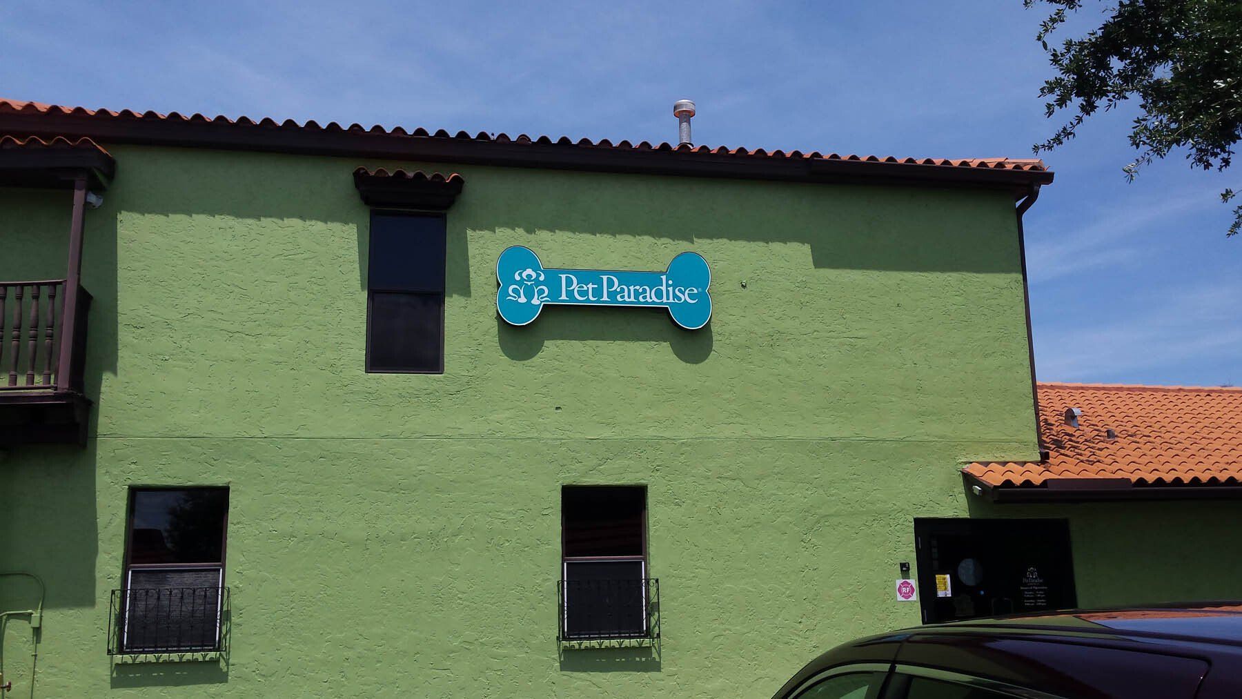 A green building with a blue sign that says ' it 's a dog 's life ' on it