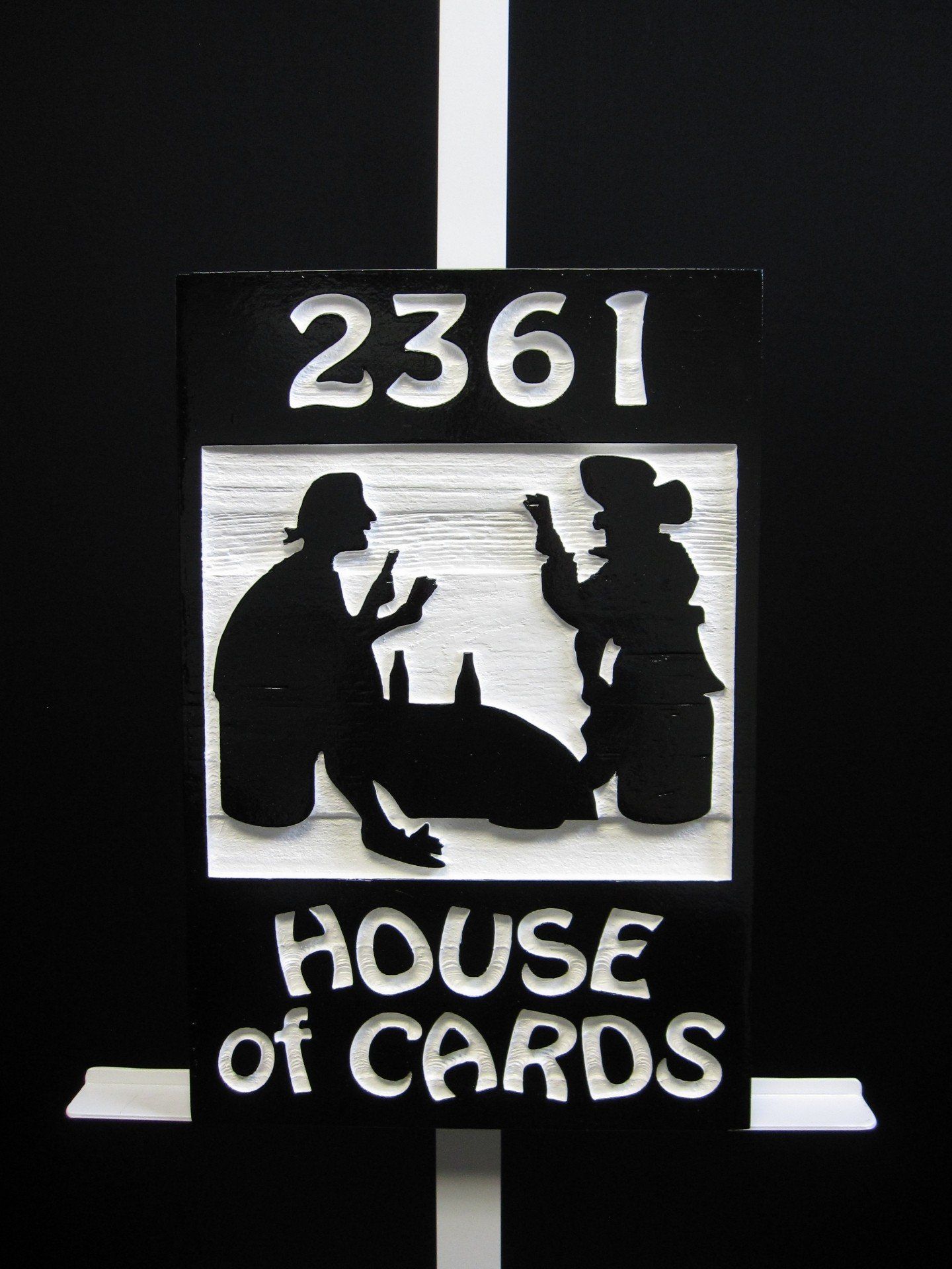 A sandblasted cedar address sign for Port Royal in Naples, painted black and white.