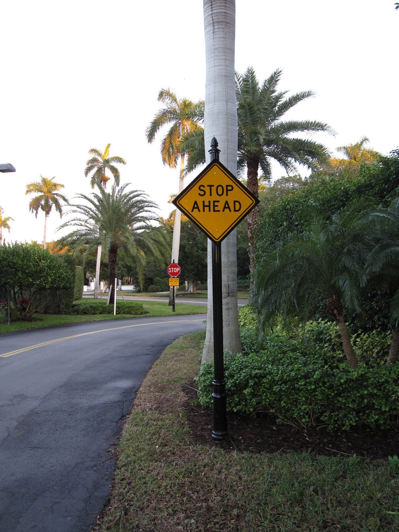 A stop ahead sign on the side of a road