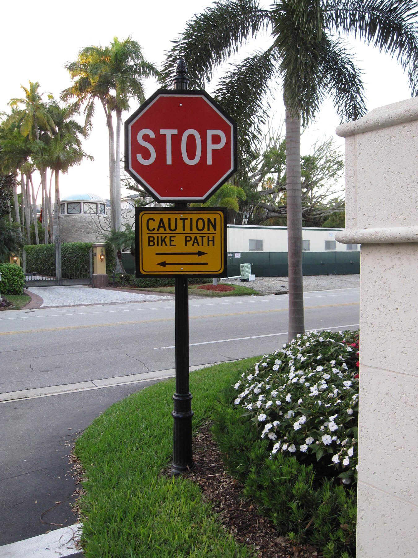 A stop sign next to a caution bike path sign