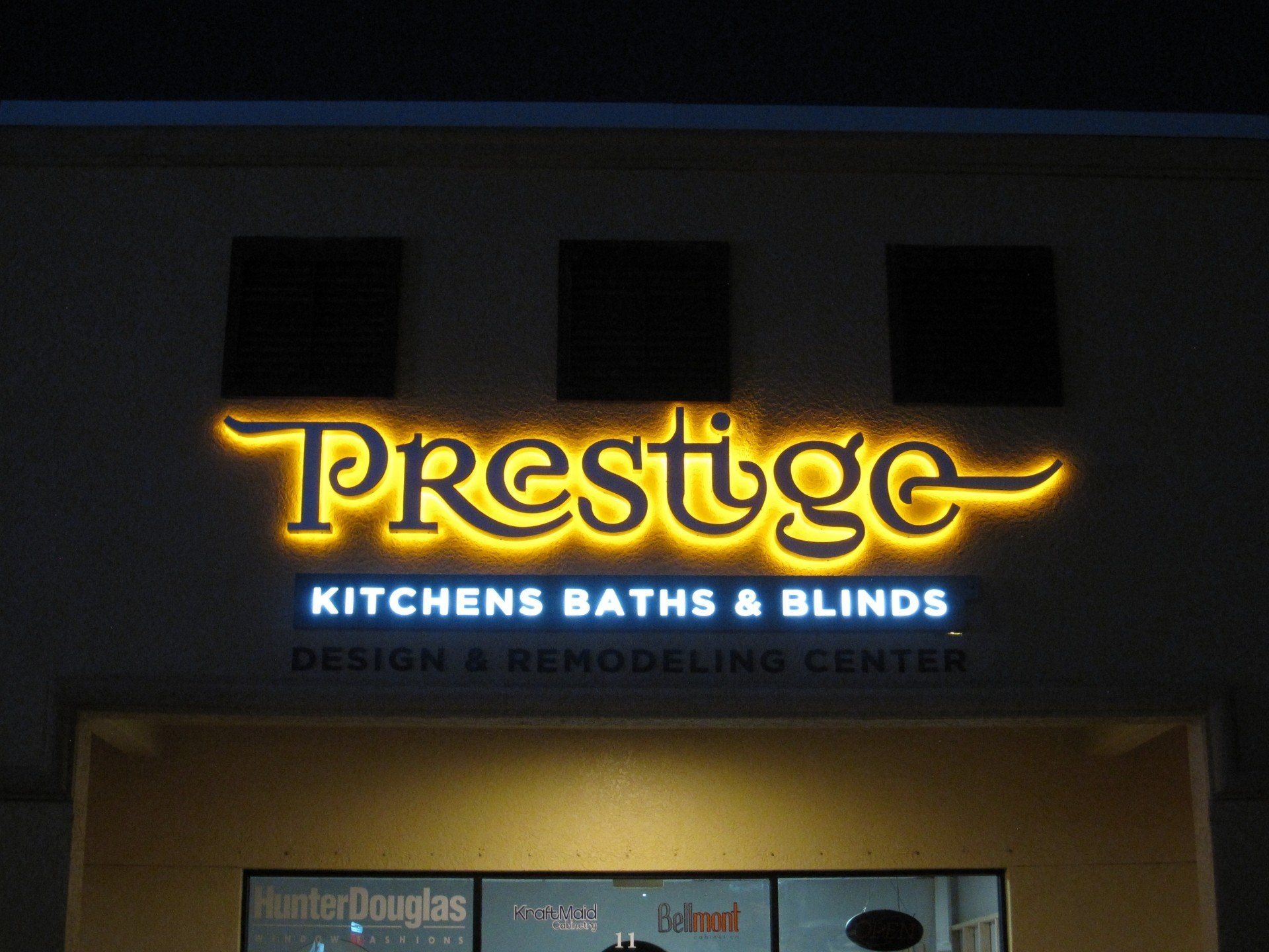 A sign for prestige kitchens baths and blinds design and remodeling center