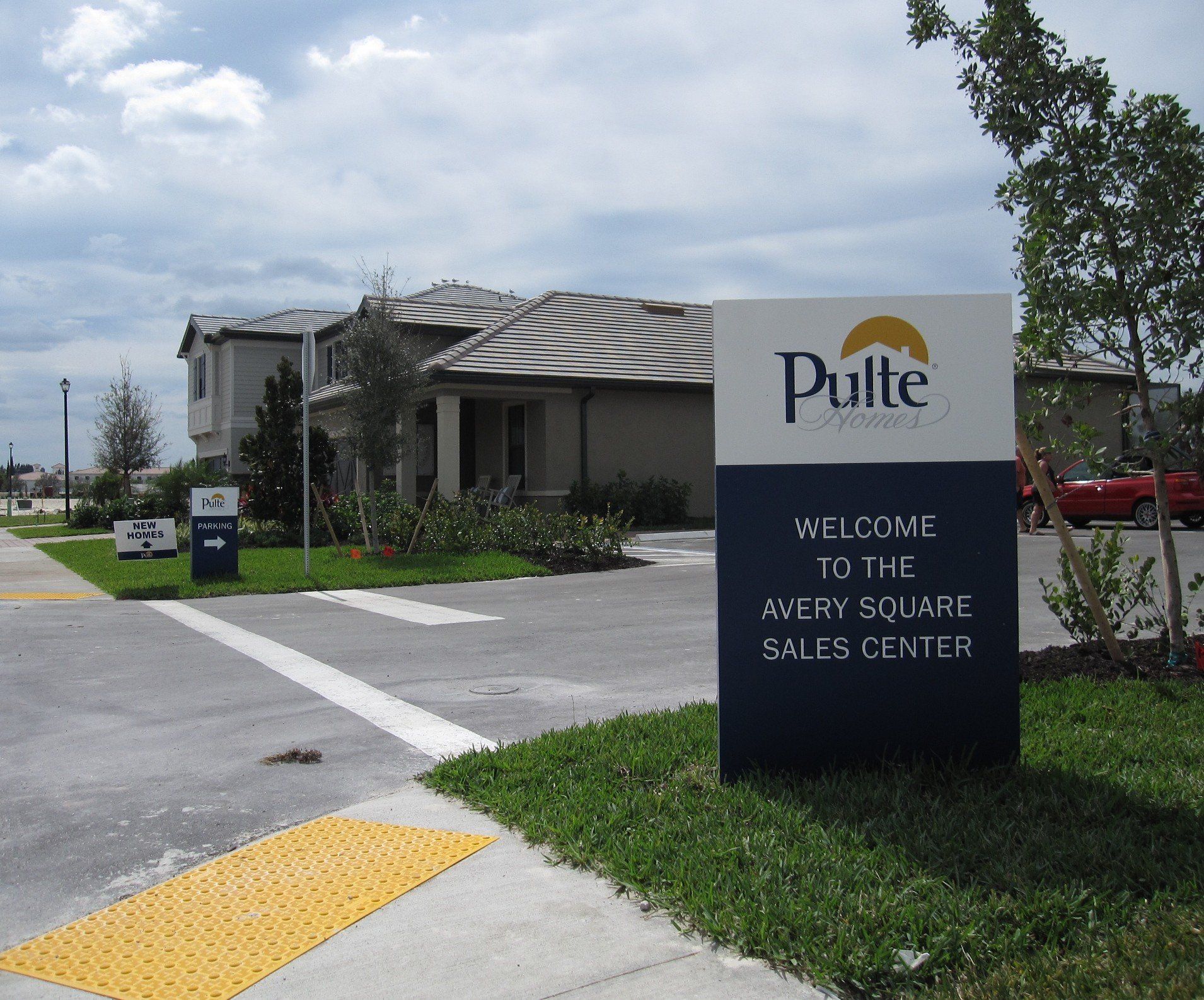 A sign that says pulte welcomes you to the avery square sales center