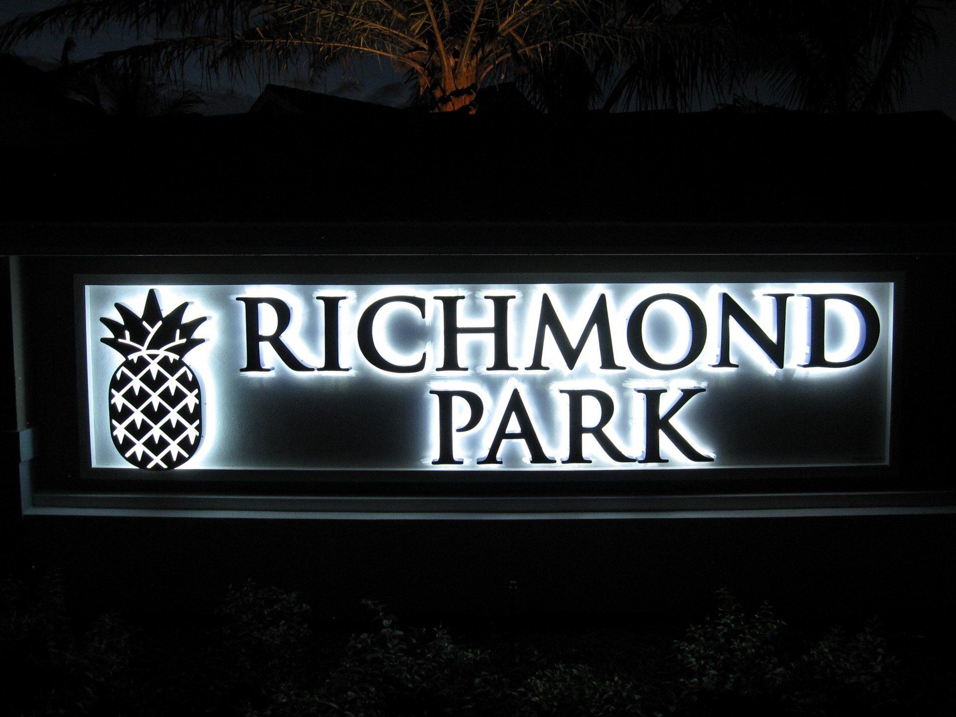 A sign for richmond park is lit up at night