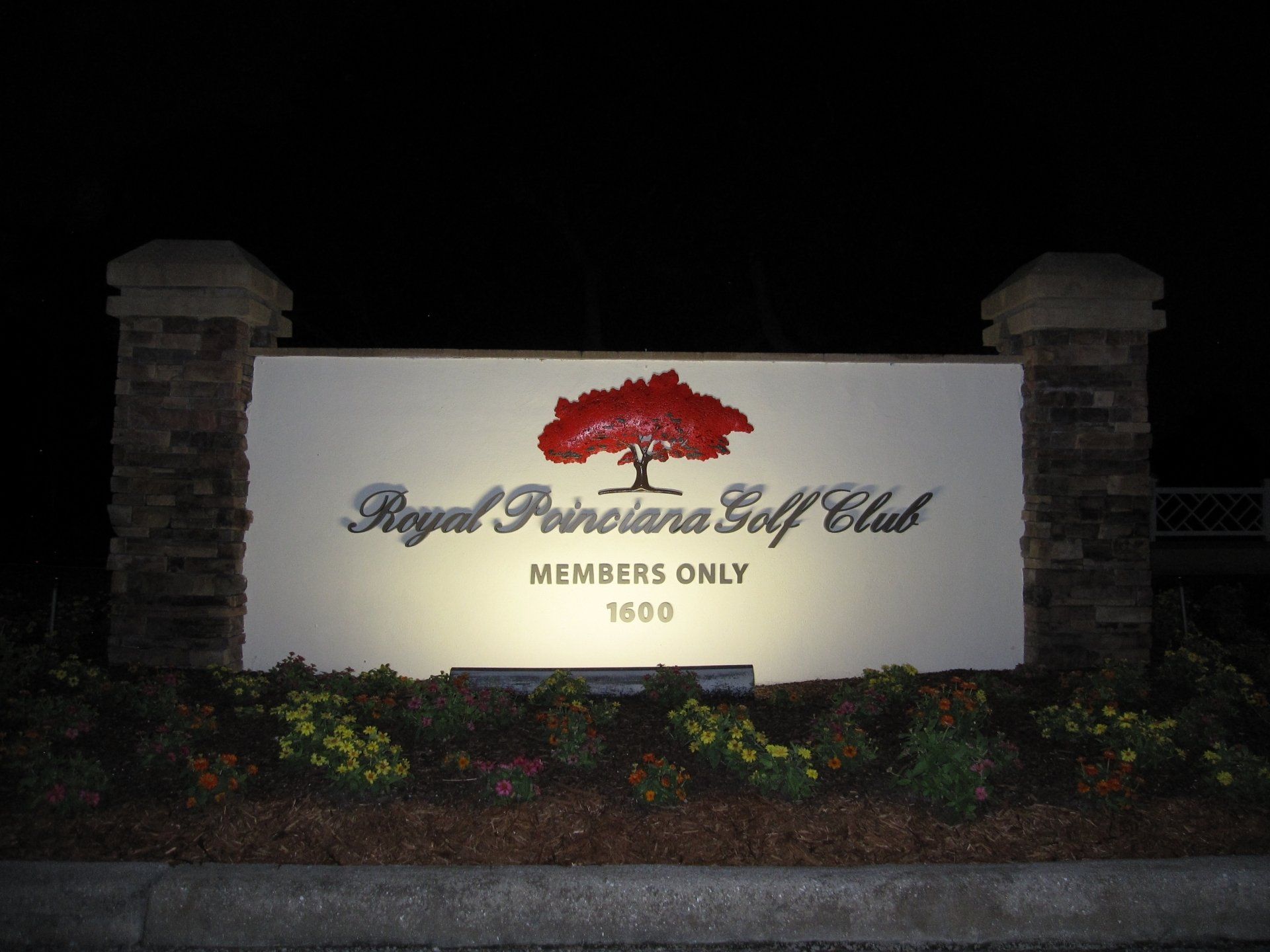 A sign for the royal princesana golf club is lit up at night