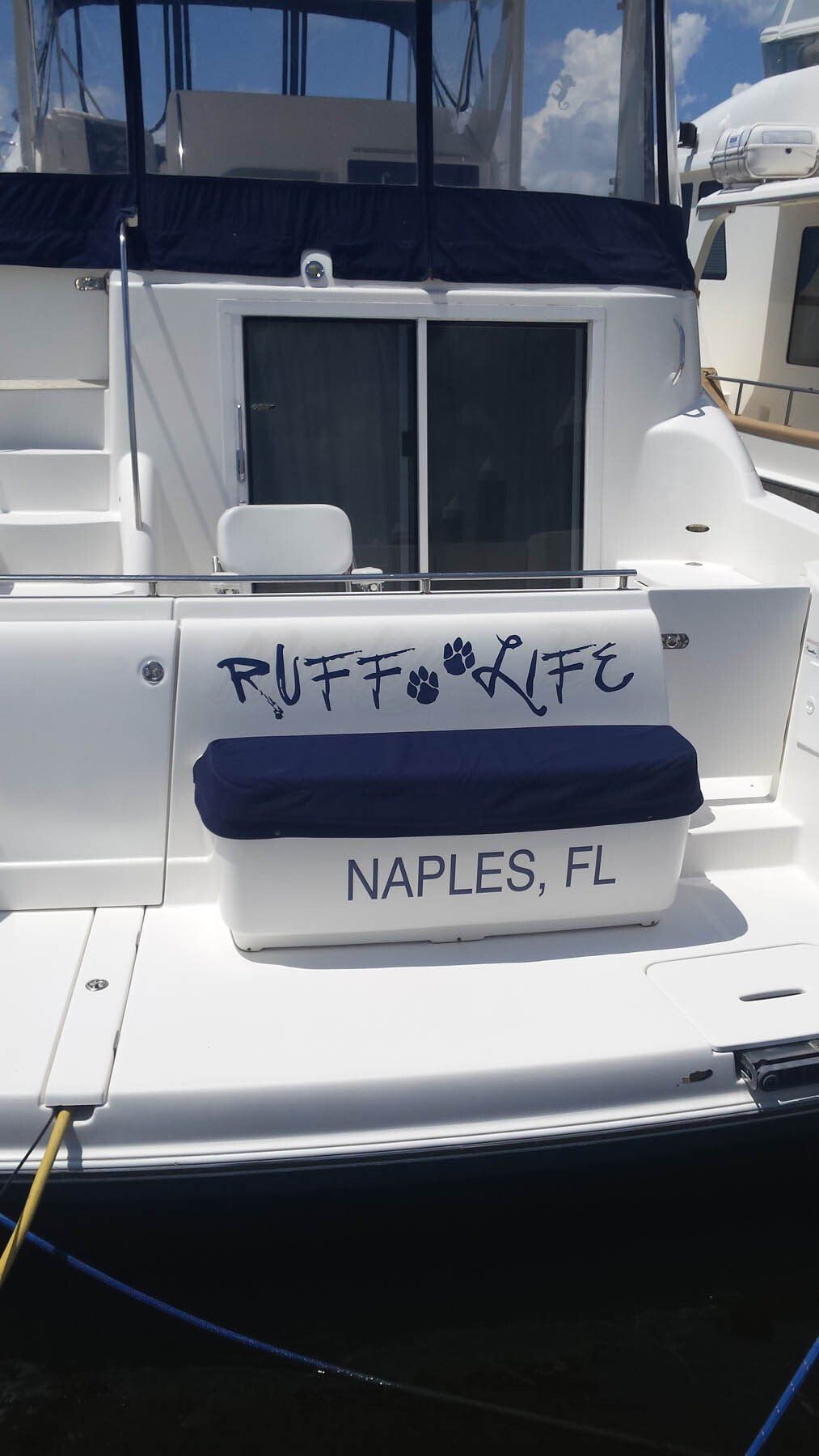 A white boat is docked in the water and has the name puffin written on the back