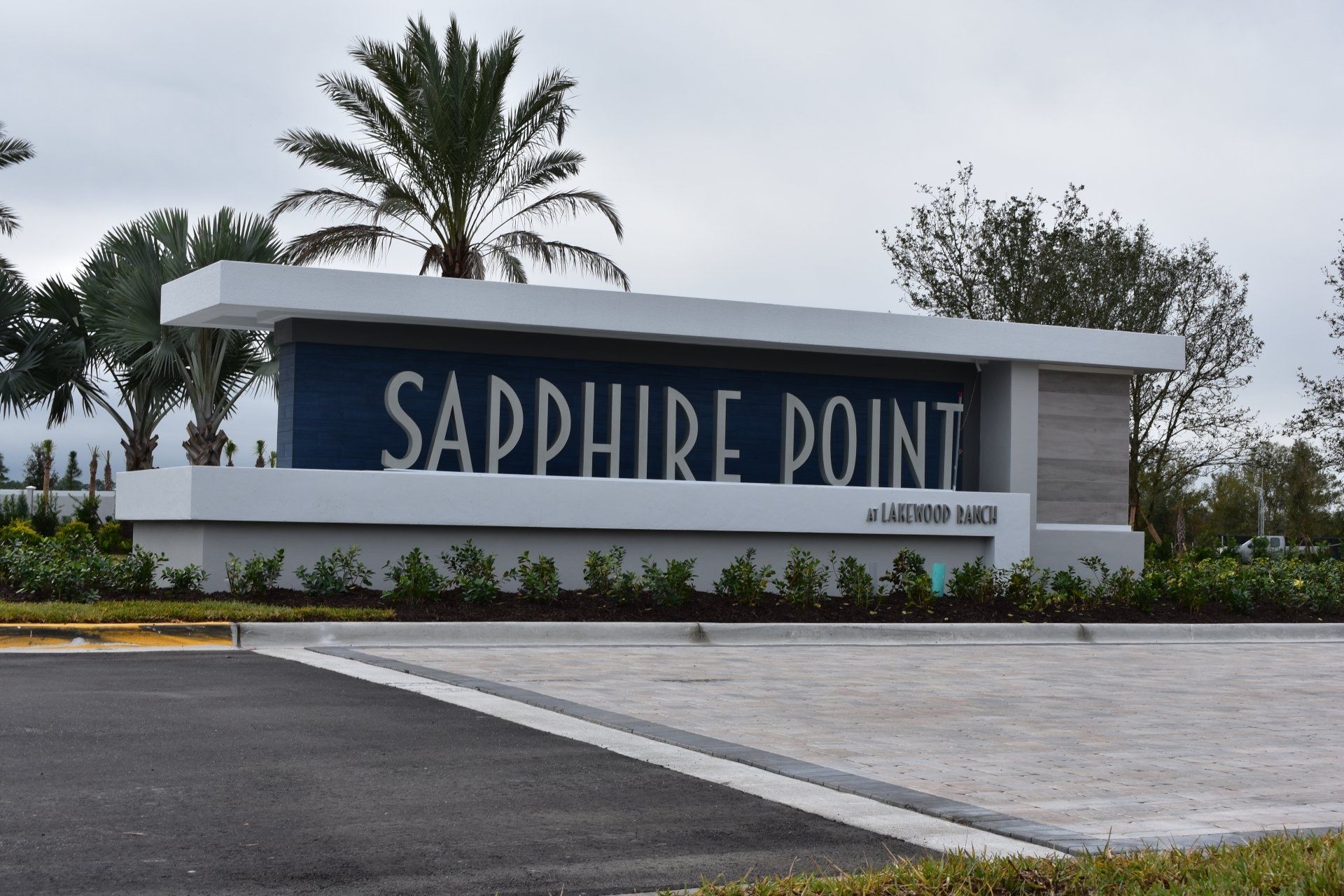 A sapphire point sign with palm trees in the background
