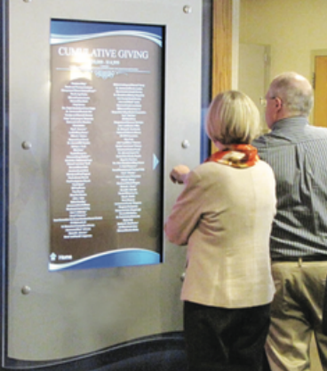 Two people looking at a screen that says cumulative giving