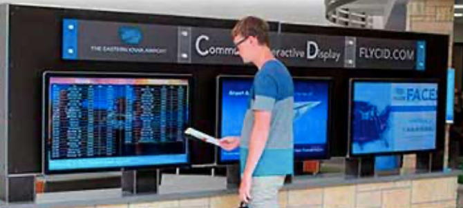 A man is standing in front of a display that says flycd.com