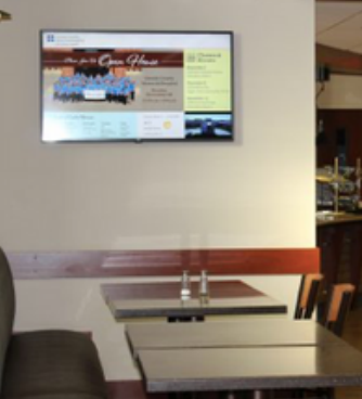 A restaurant with tables and a flat screen tv on the wall