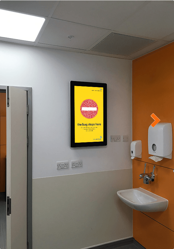 A bathroom with a sink and a yellow sign on the wall.