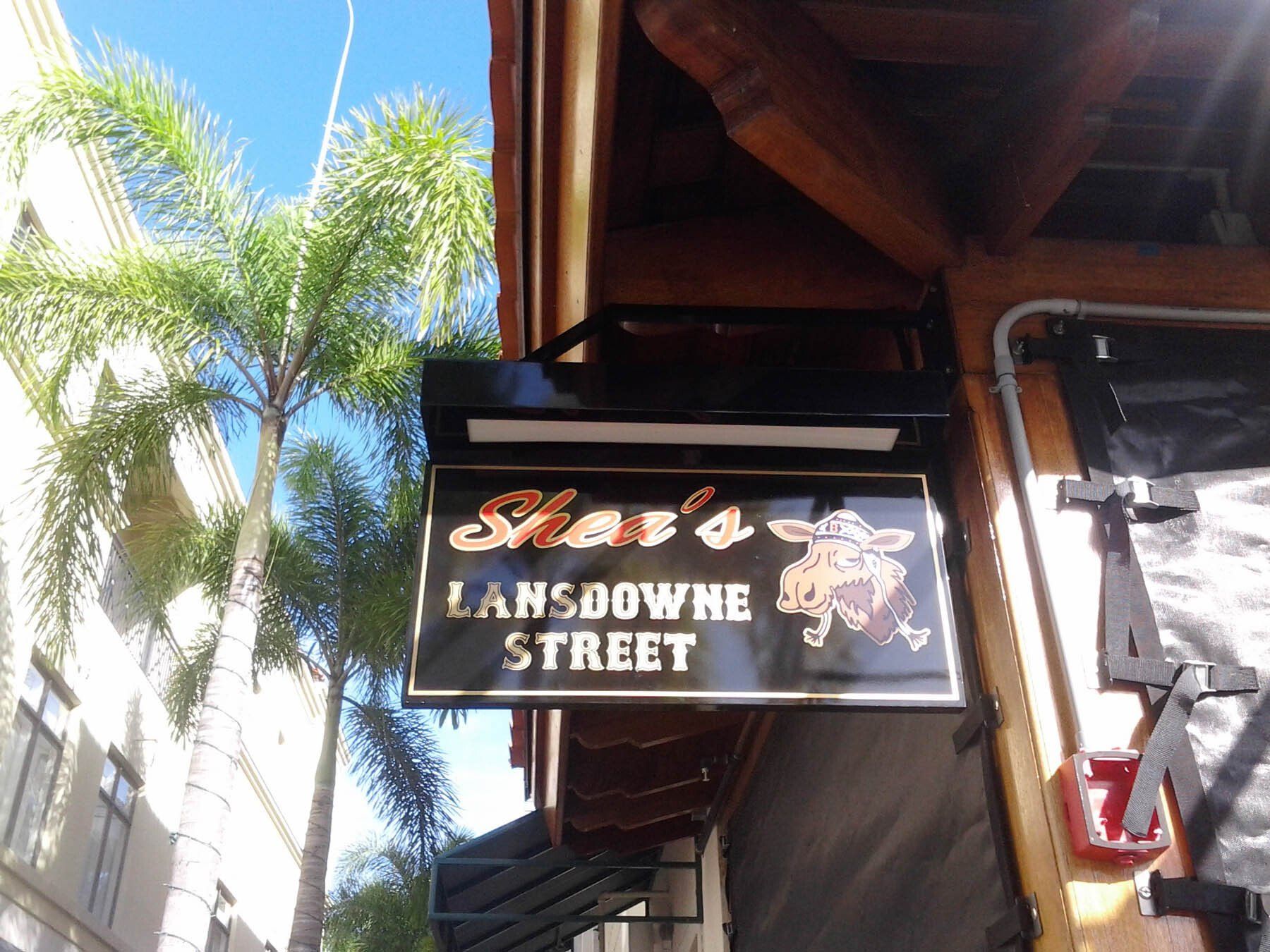 A sign for shaw 's landowne street hangs from the side of a building