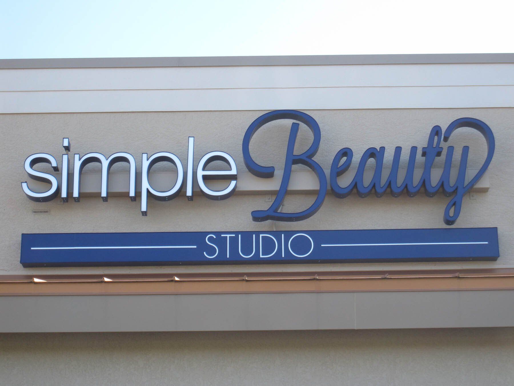 A simple beauty studio sign on the side of a building