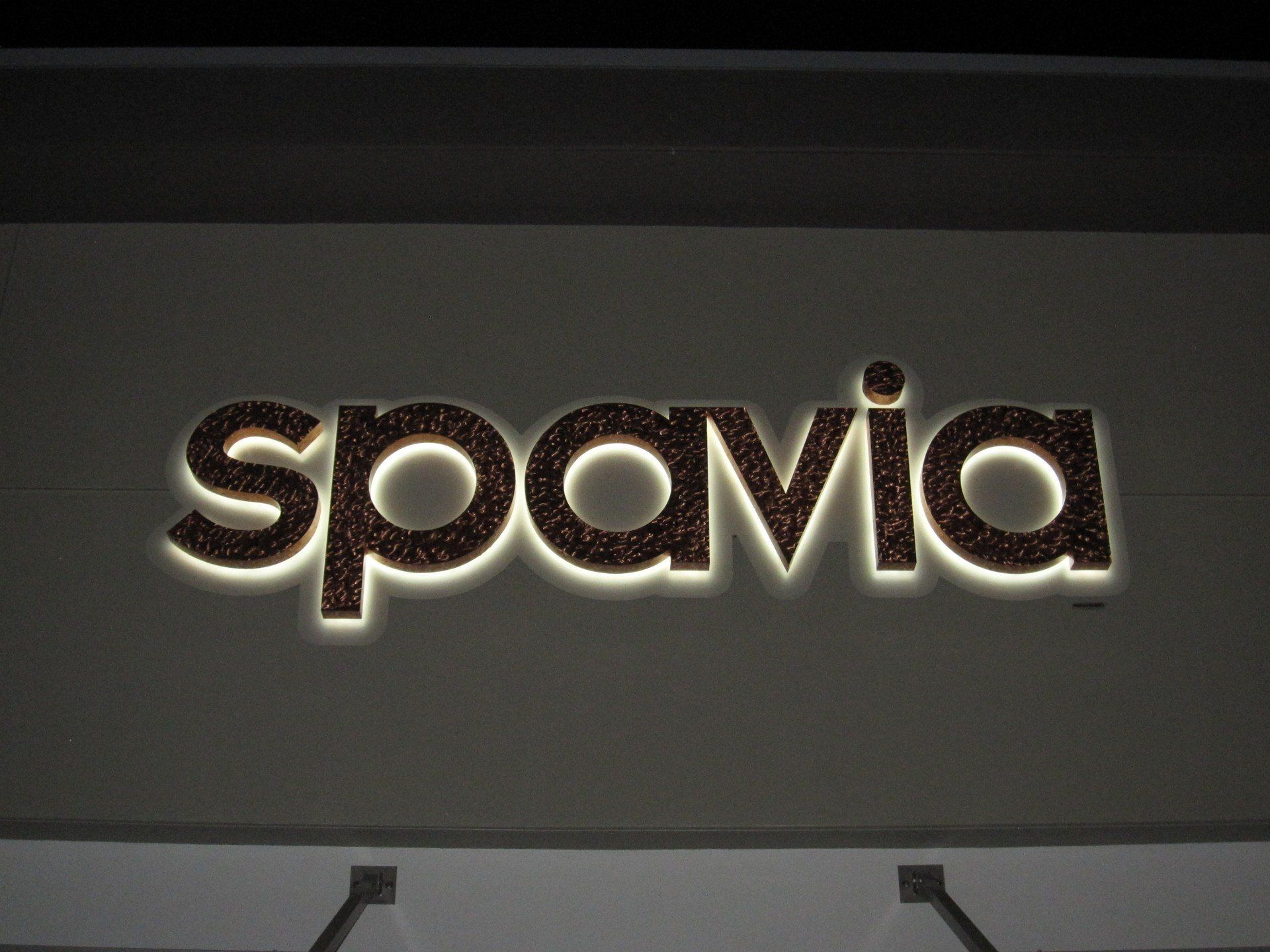 A sign that says spavia is lit up at night
