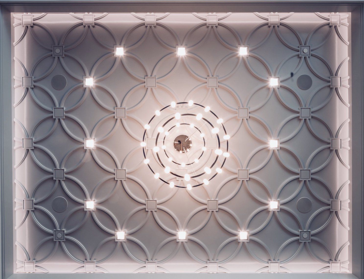 A ceiling with a circular pattern and lights on it