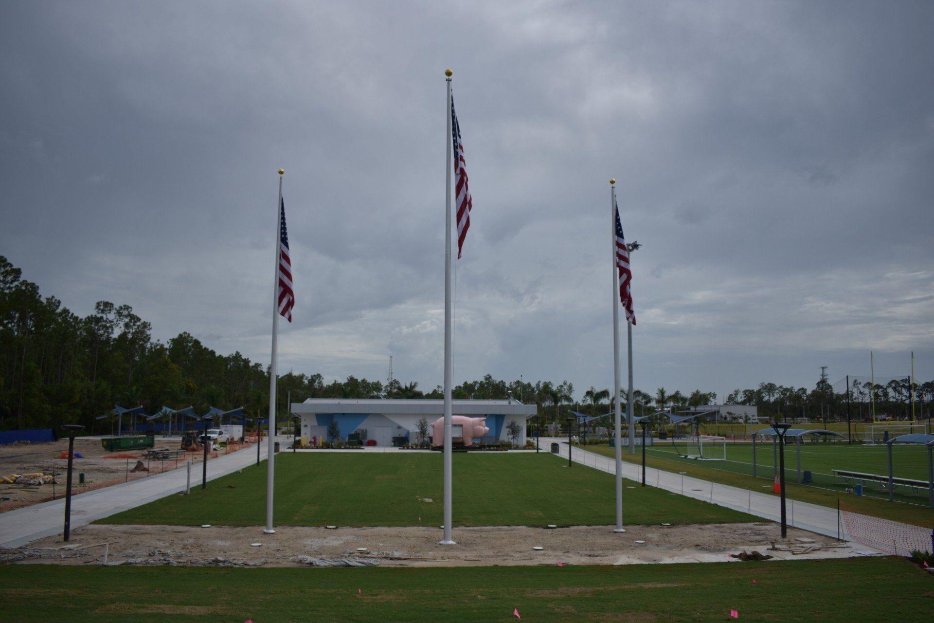 Three american flags are flying in front of a building