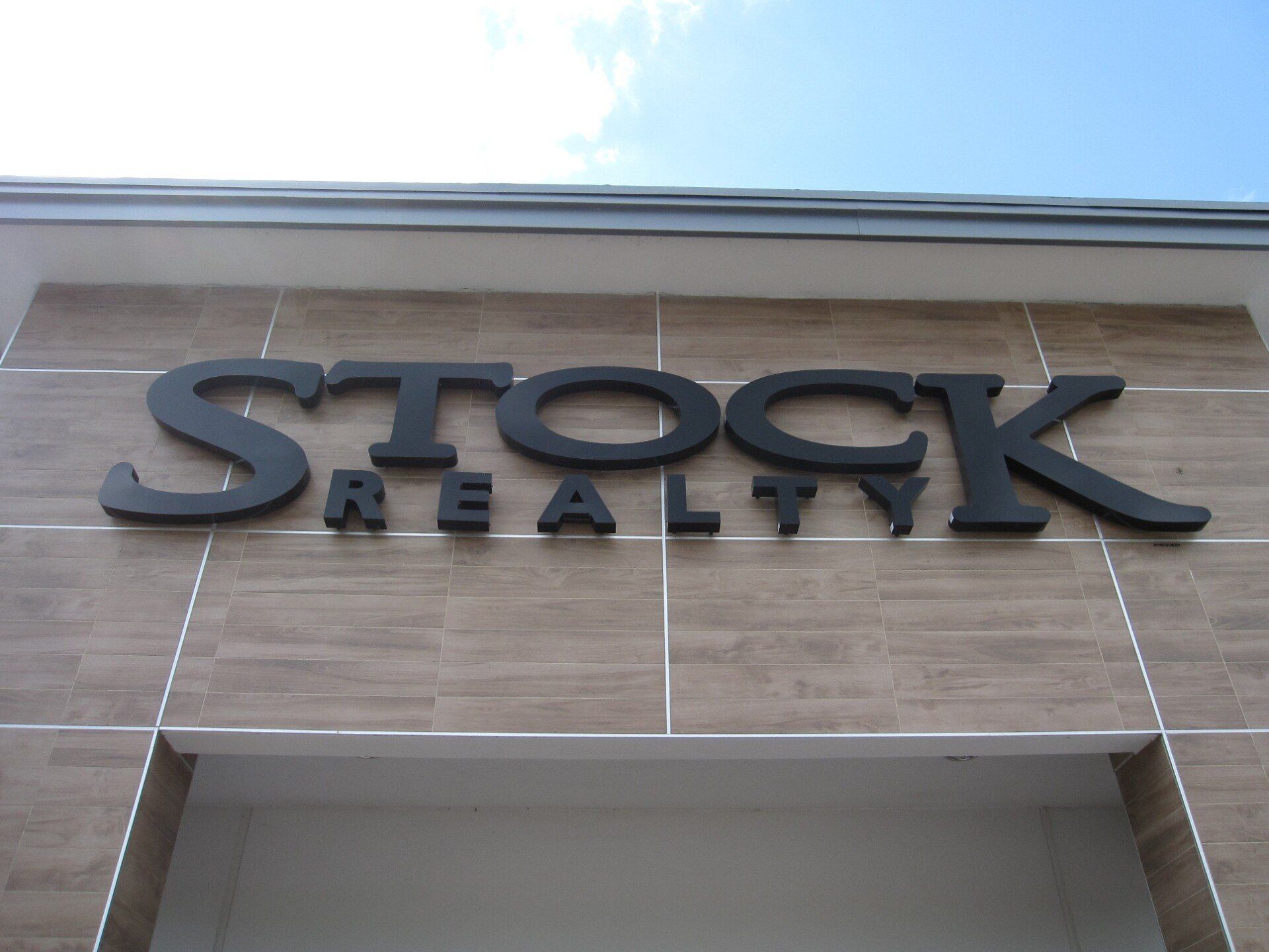 A stock realty sign on the side of a building