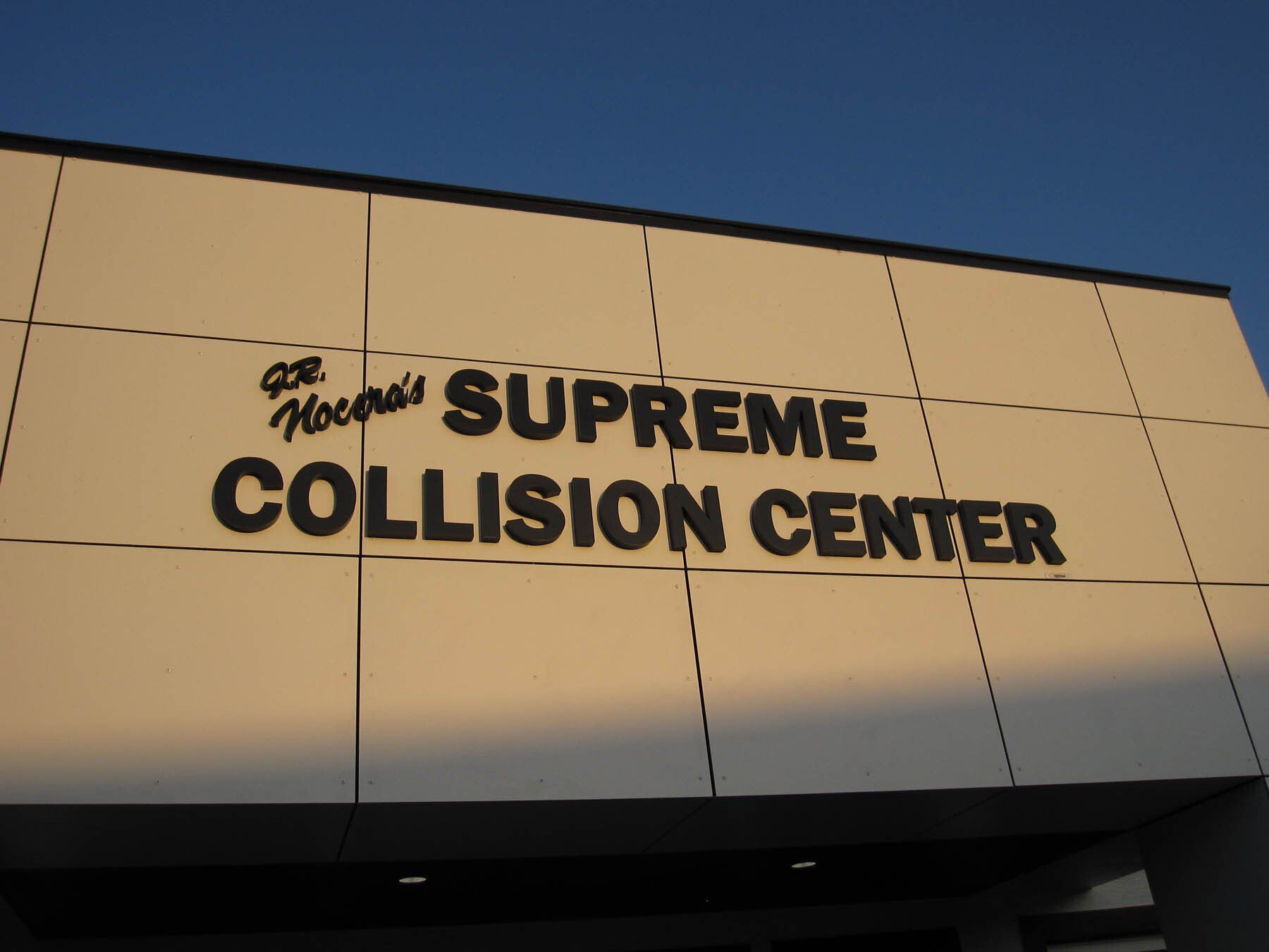A supreme collision center sign on a building