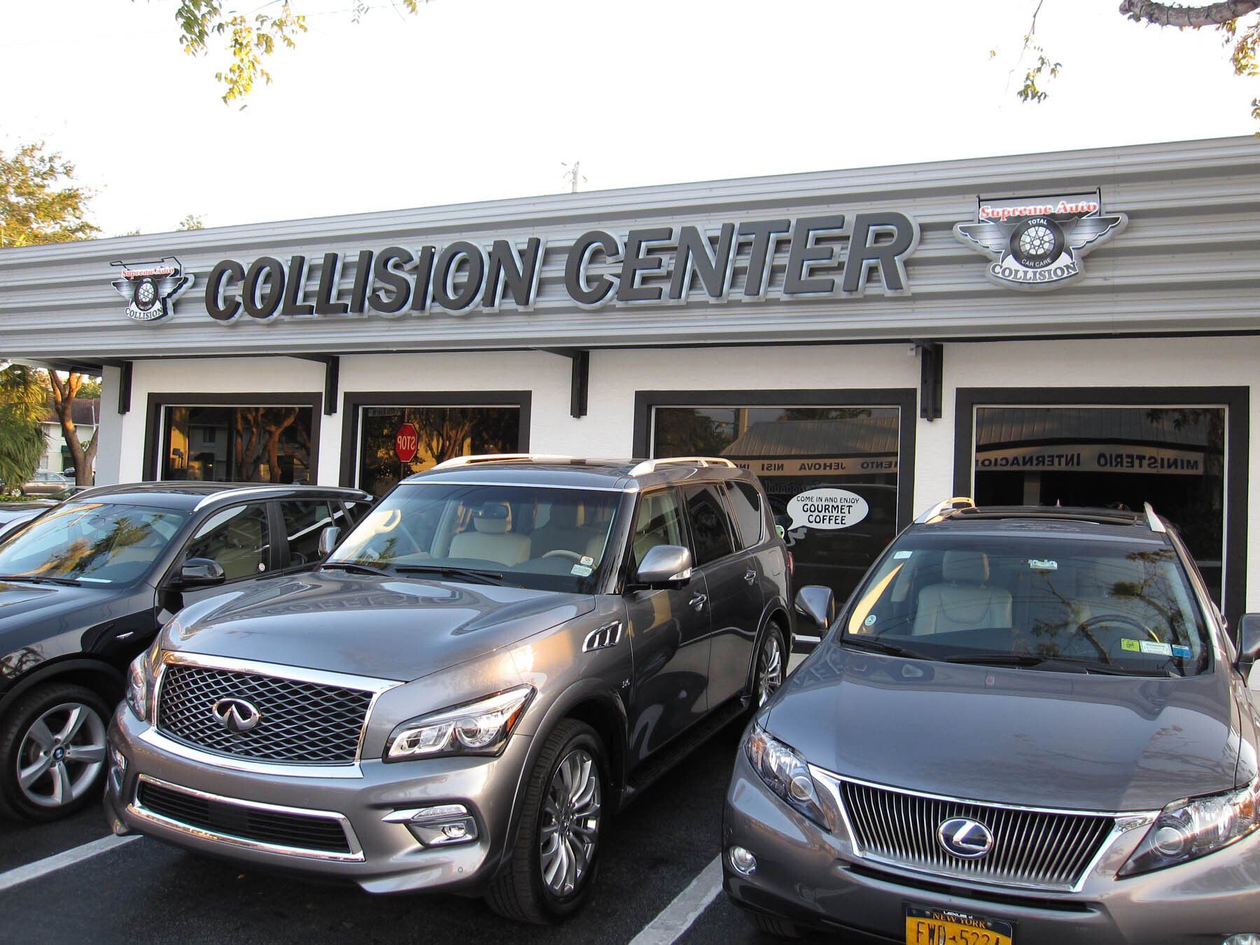 Several cars are parked in front of a collision center