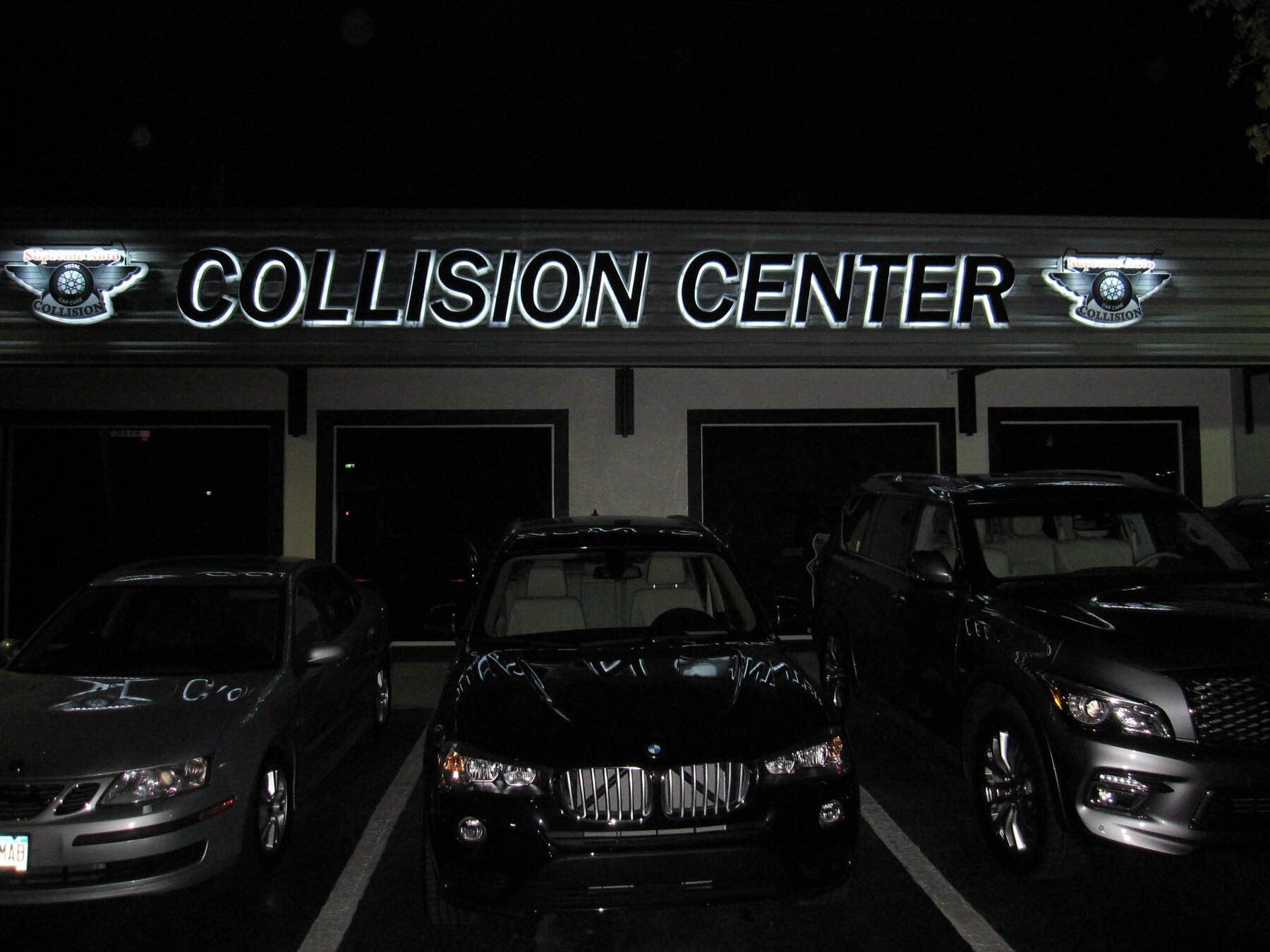 Several cars are parked in front of a collision center