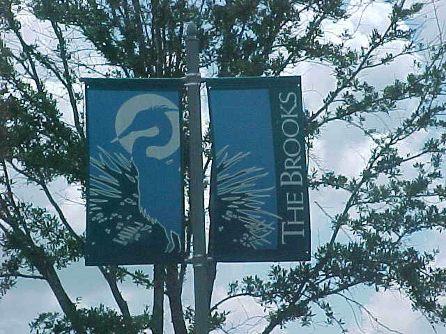 A sign for the brooks is hanging from a pole