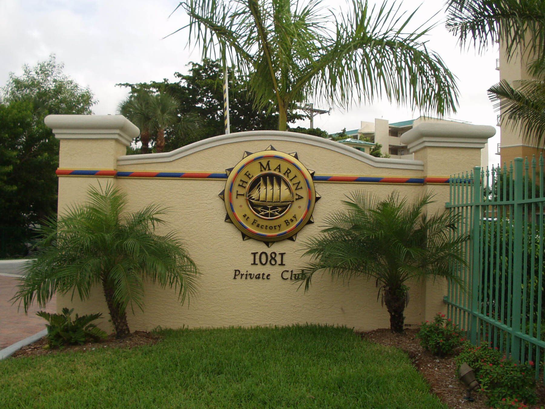 A sign for the marina private club with palm trees in front of it