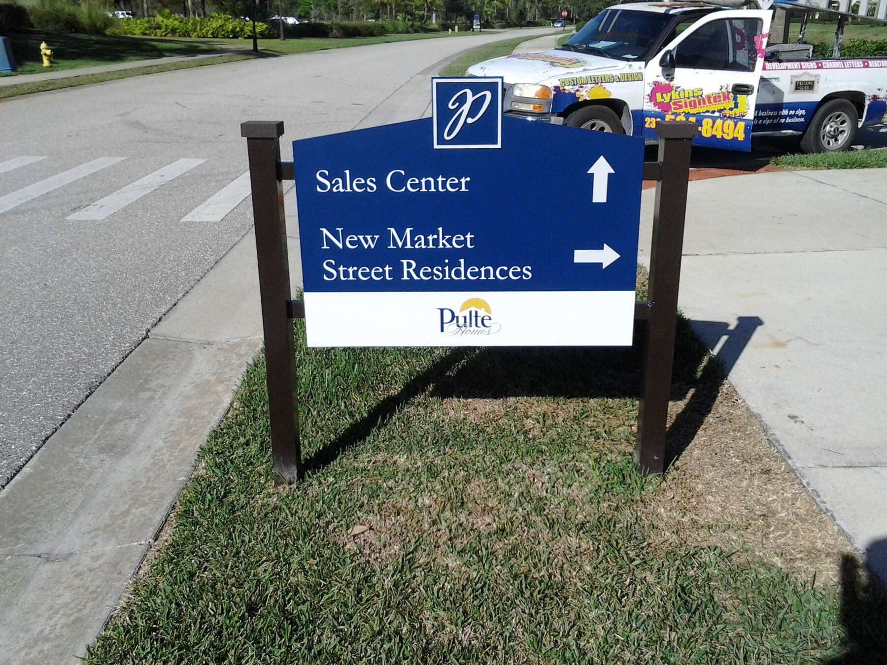 A blue sign that says sales center new market street residences