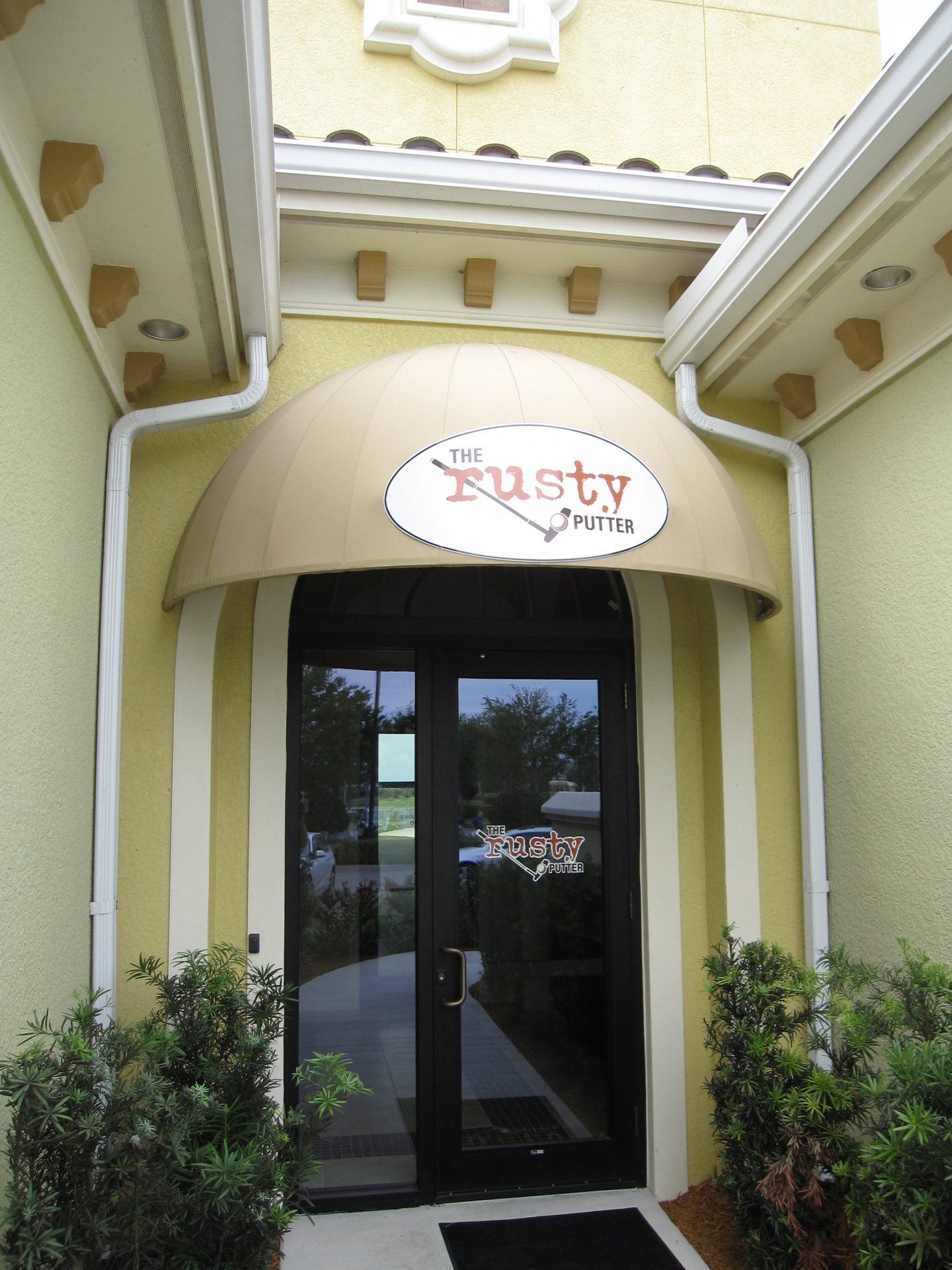 A yellow building with a sign that says rusty