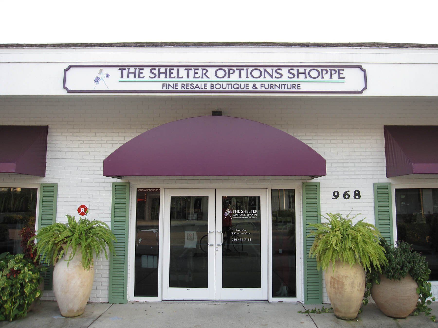 The shelter options shoppe has a purple awning over the door