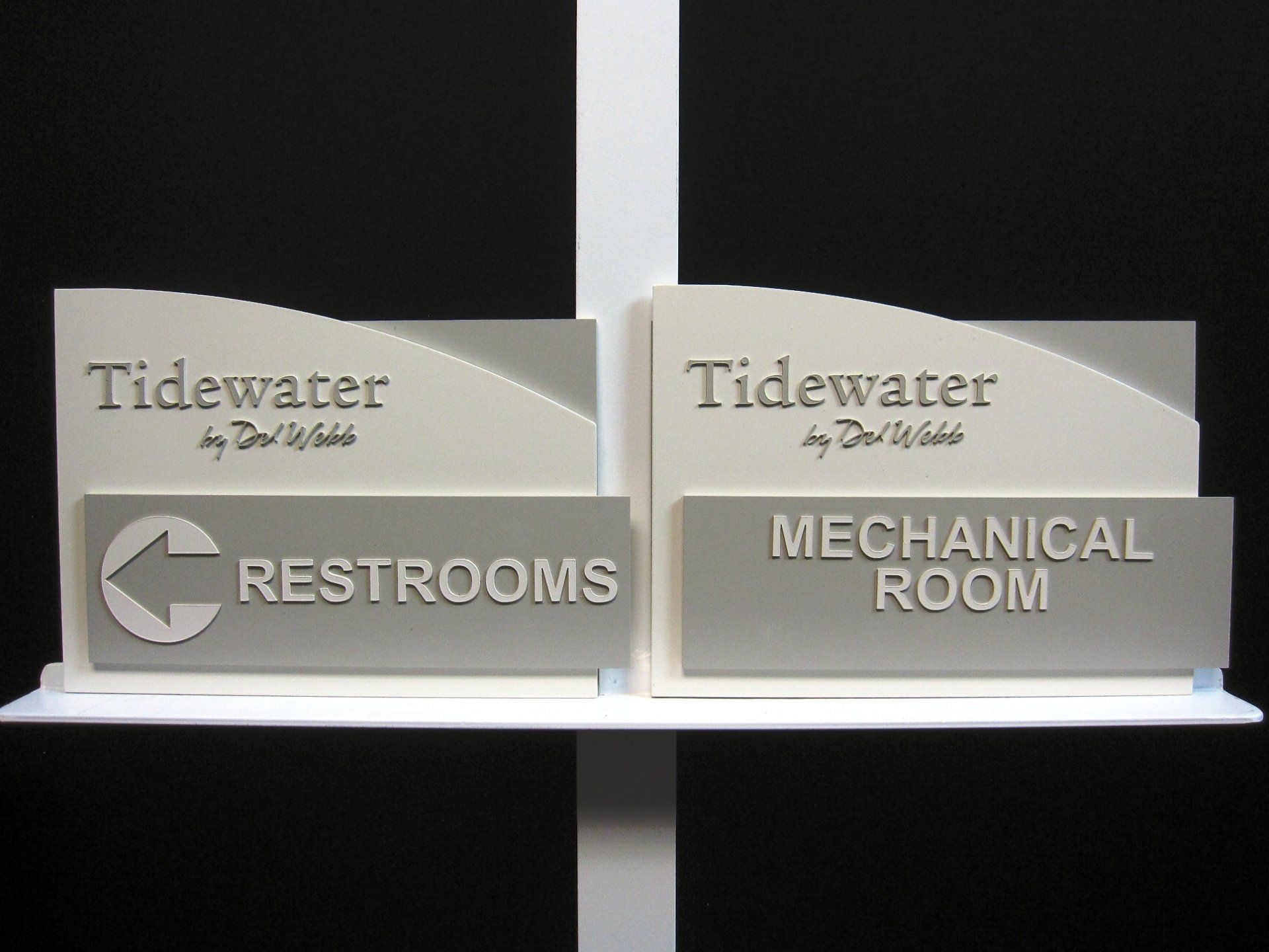 Two signs on a shelf that say tidewater restrooms and mechanical room