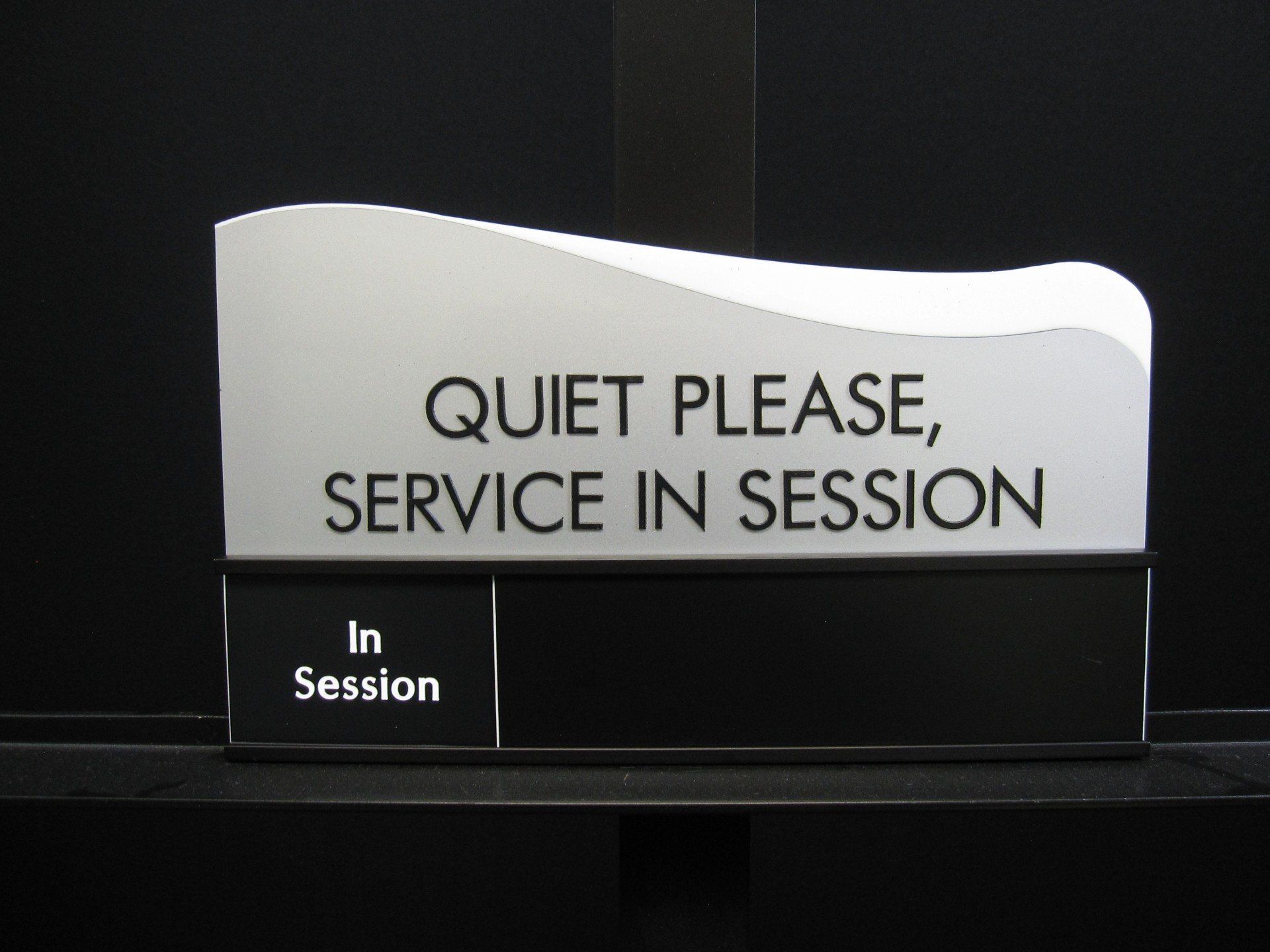 A sign that says quiet please service in session
