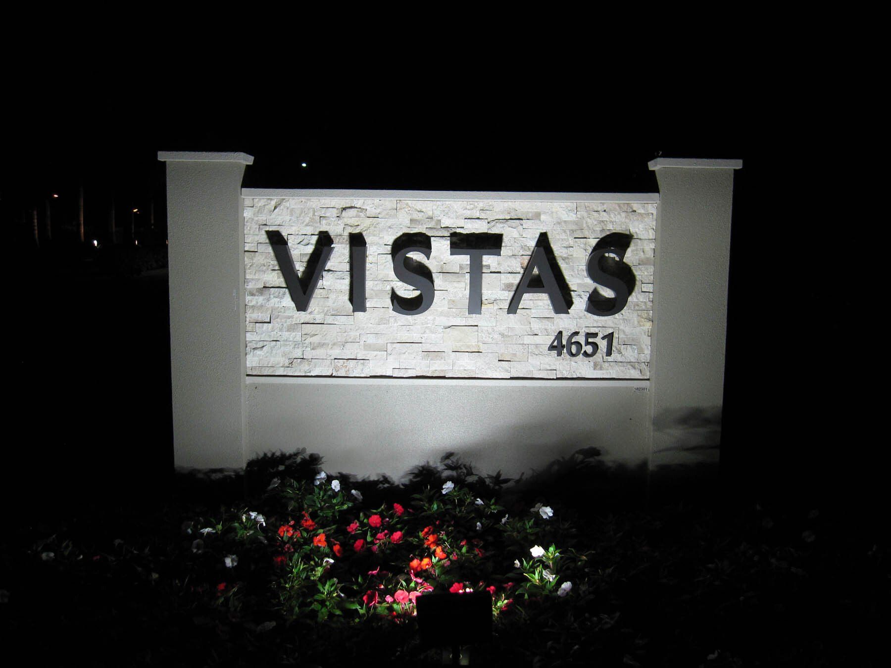 A sign for vistas is lit up at night